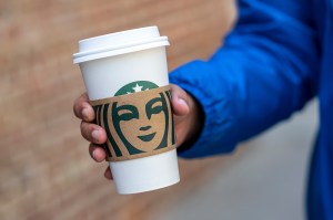 A pedestrian carries a Starbucks branded cup in San Francisco, California, U.S., on Thursday, April 28, 2022.