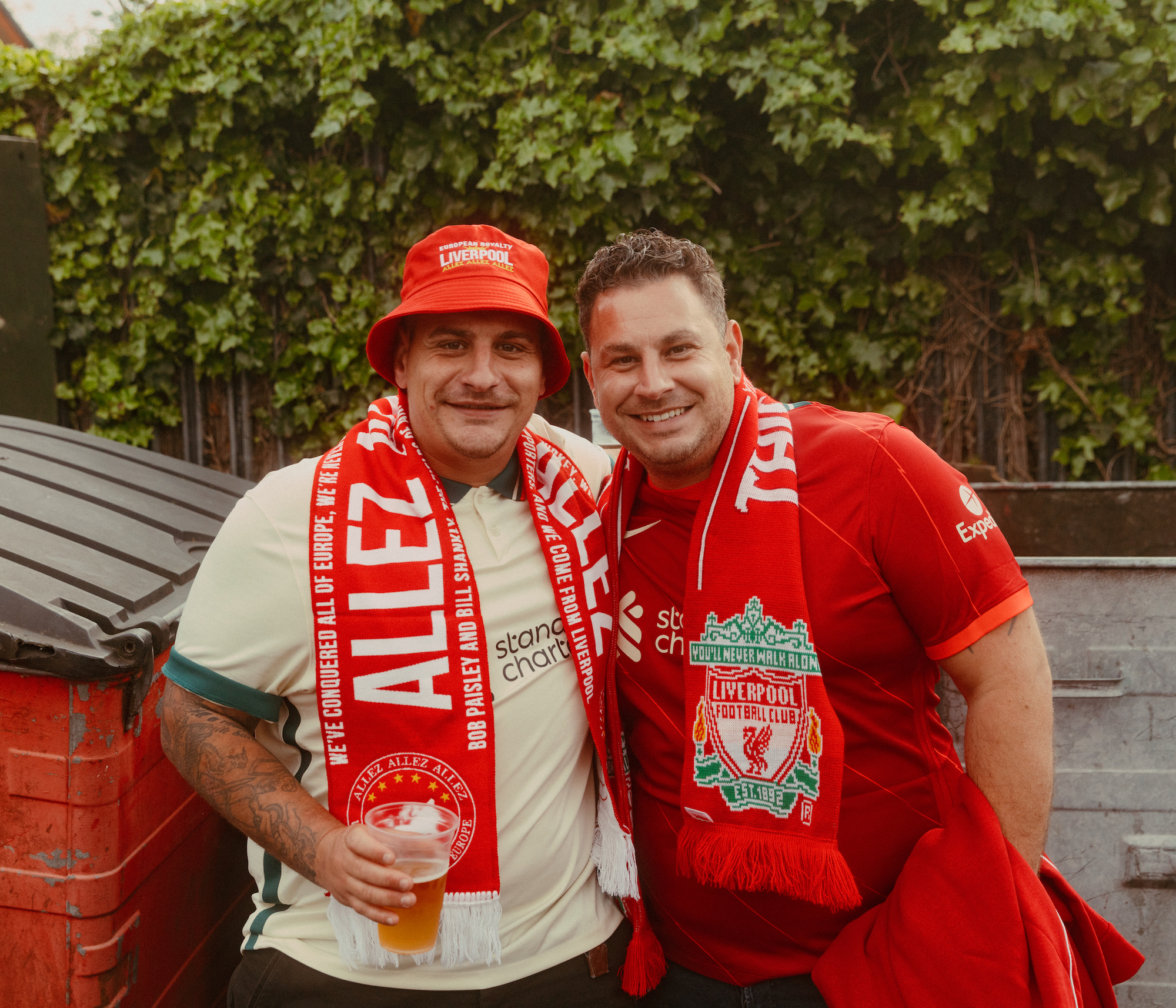 Two fans pose for a photo in full Liverpool gear