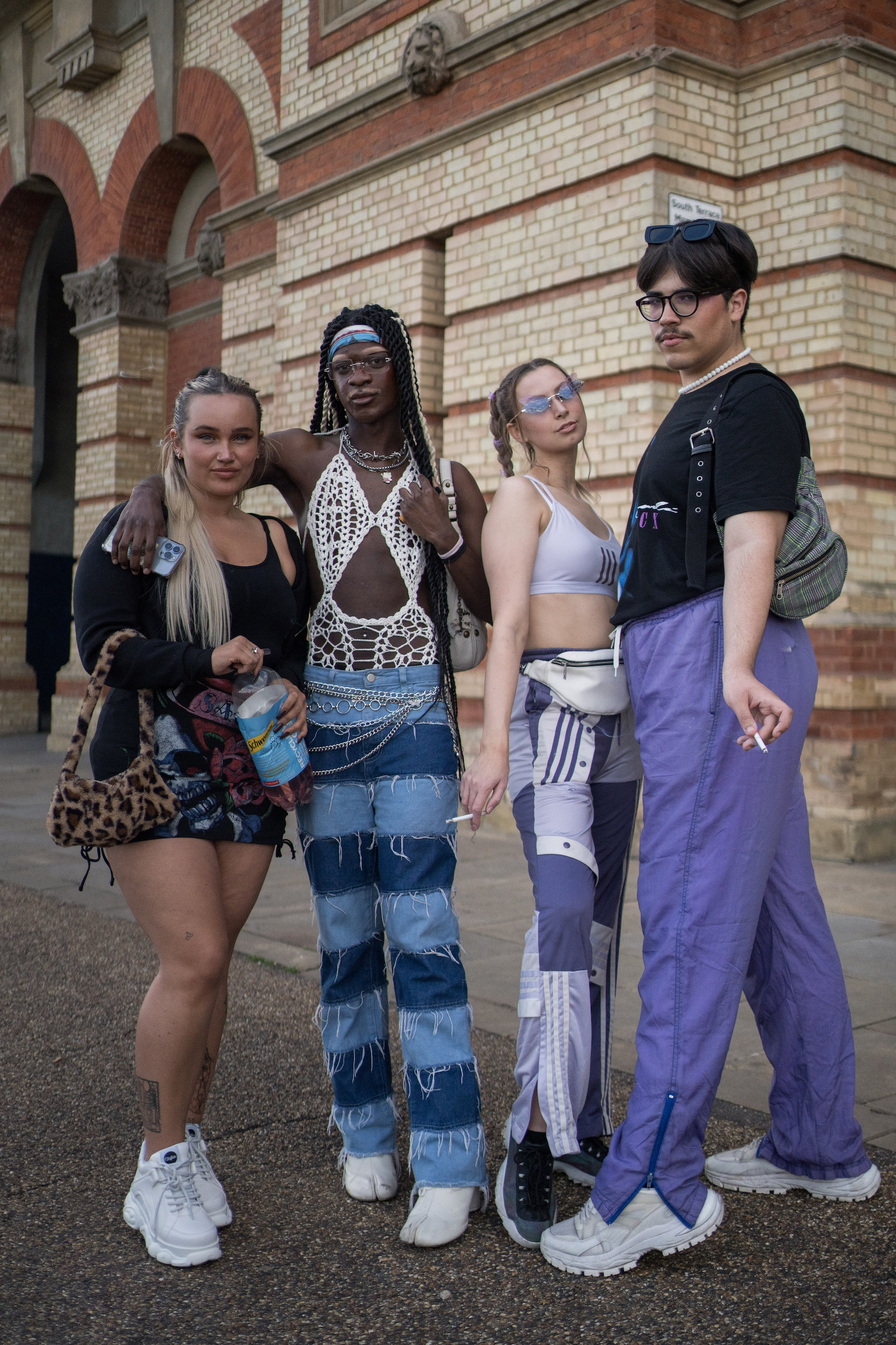 Four Charli XCX fans at Alexandra Palace, London, posing outside venue in purple and blue