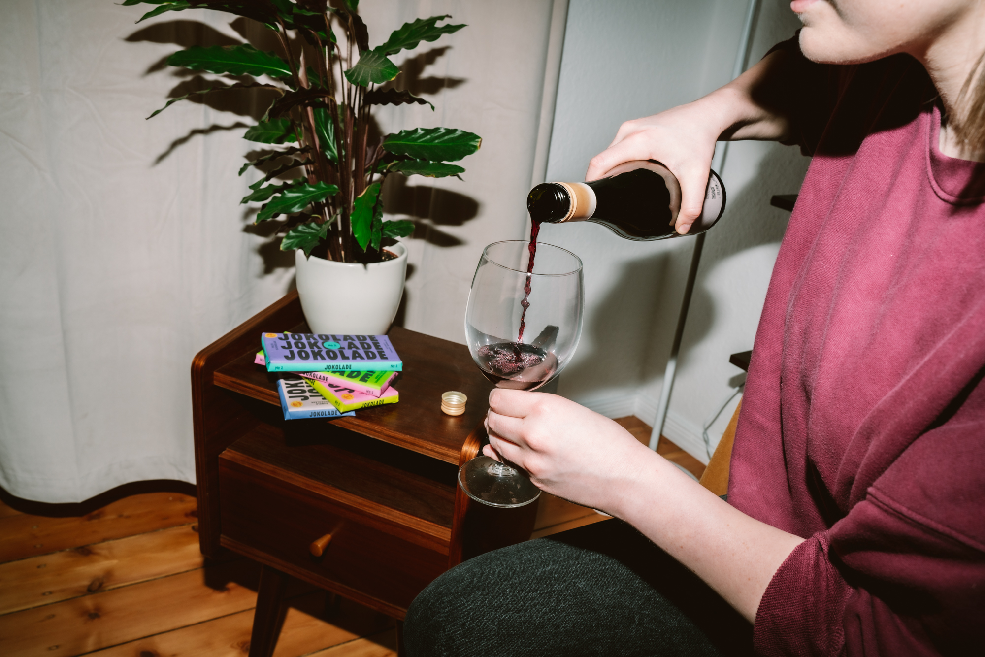 Die Autorin gießt sich Rotwein von Joko Winterscheidt in ein Weinglas ein.