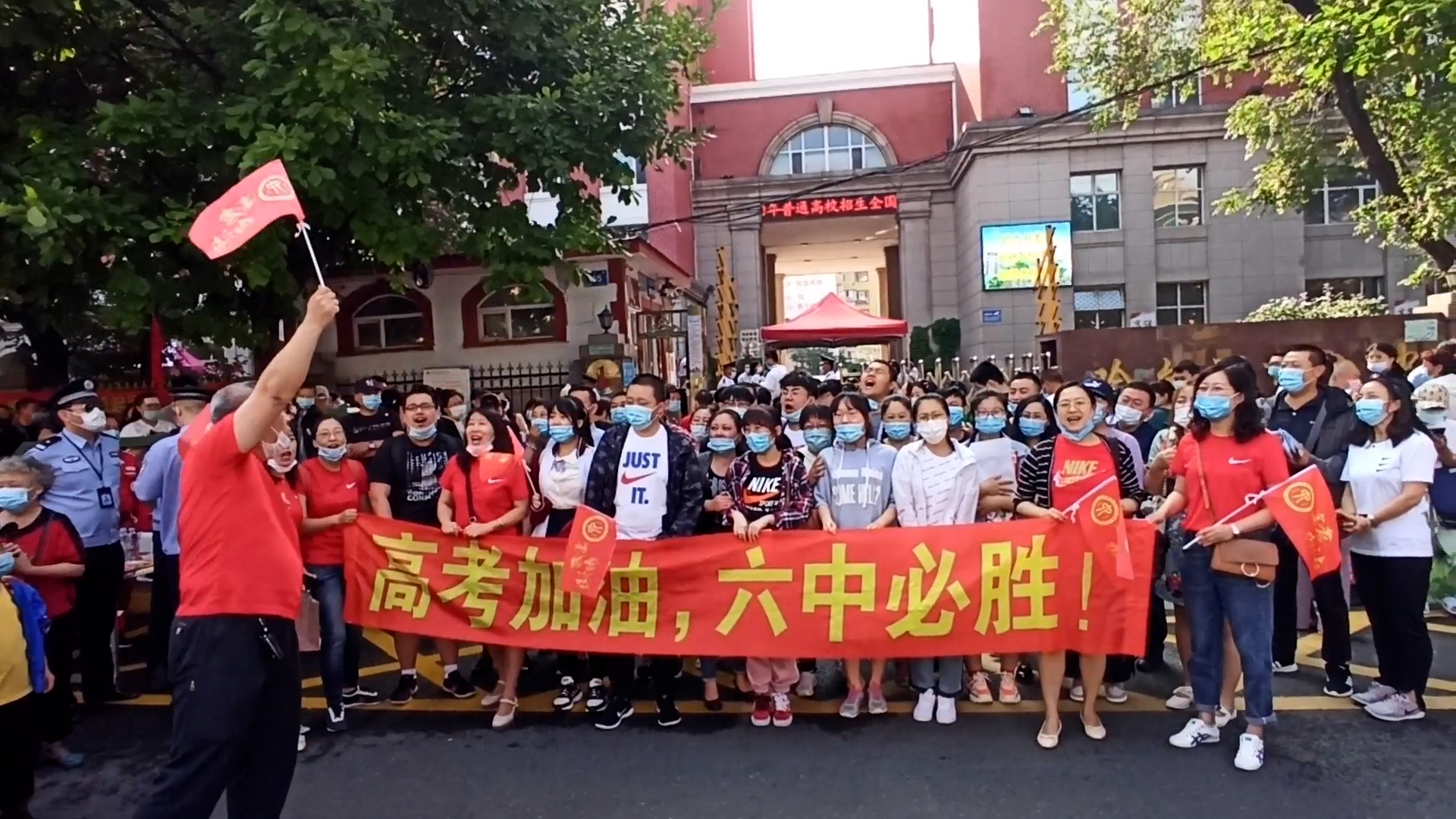 Students and parents encourage one other outside a high school on the eve of a college entrance exam.