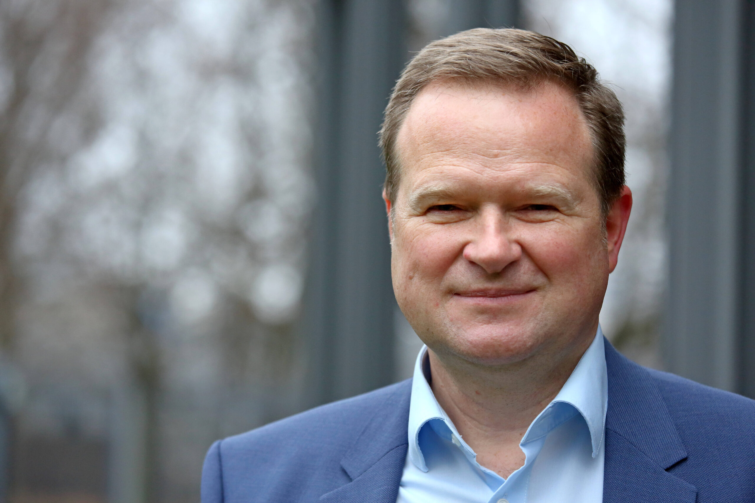 Der SPD-Politiker Frank Schwabe lächelt in die Kamera. Er trägt ein blaues Hemd.