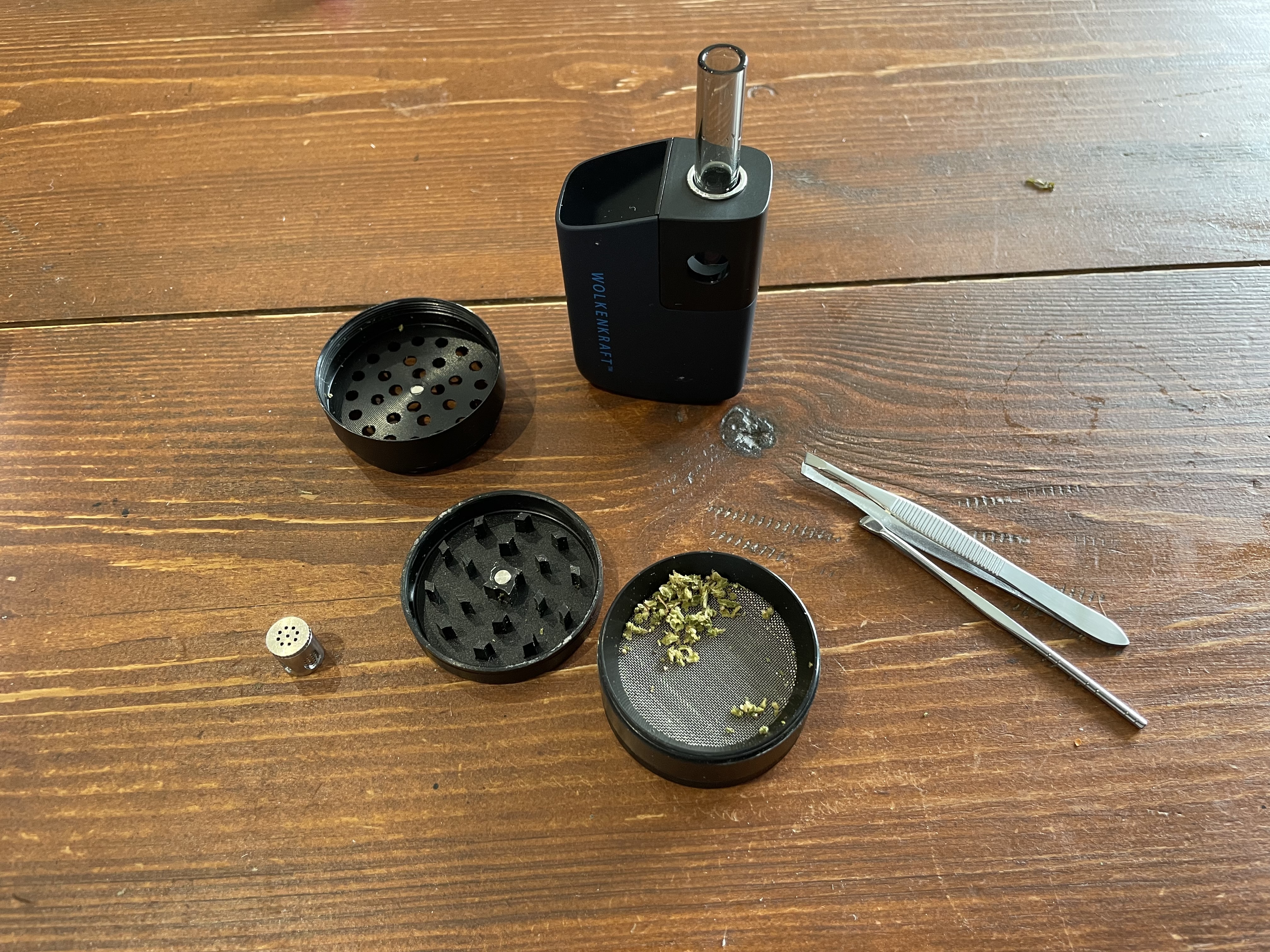 Weed in a grinder next to a vape.