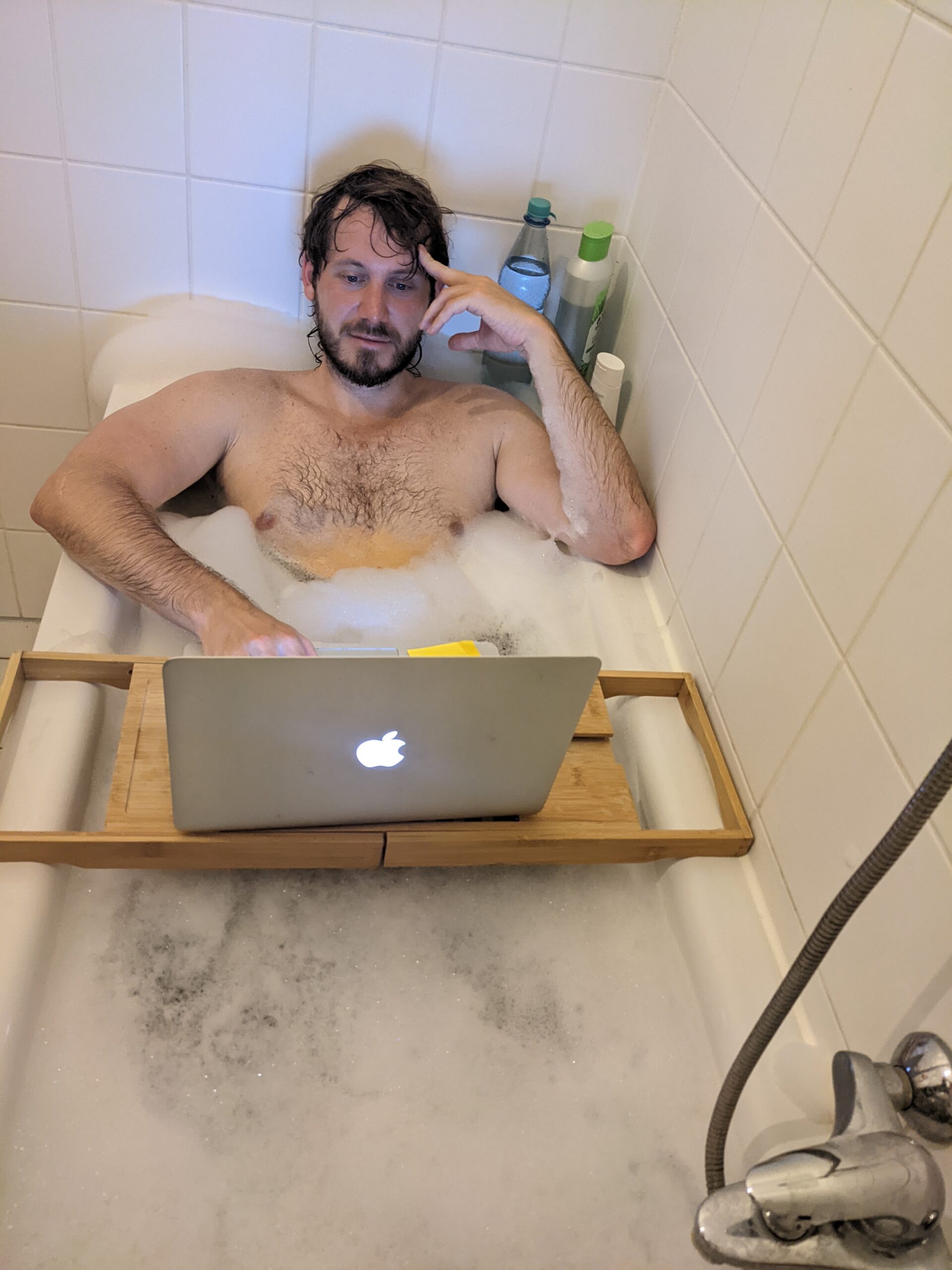 Ein Mann arbeitet in der Badewanne am Laptop. Baden wird bald super teuer weil der Gaspreis so hoch ist.