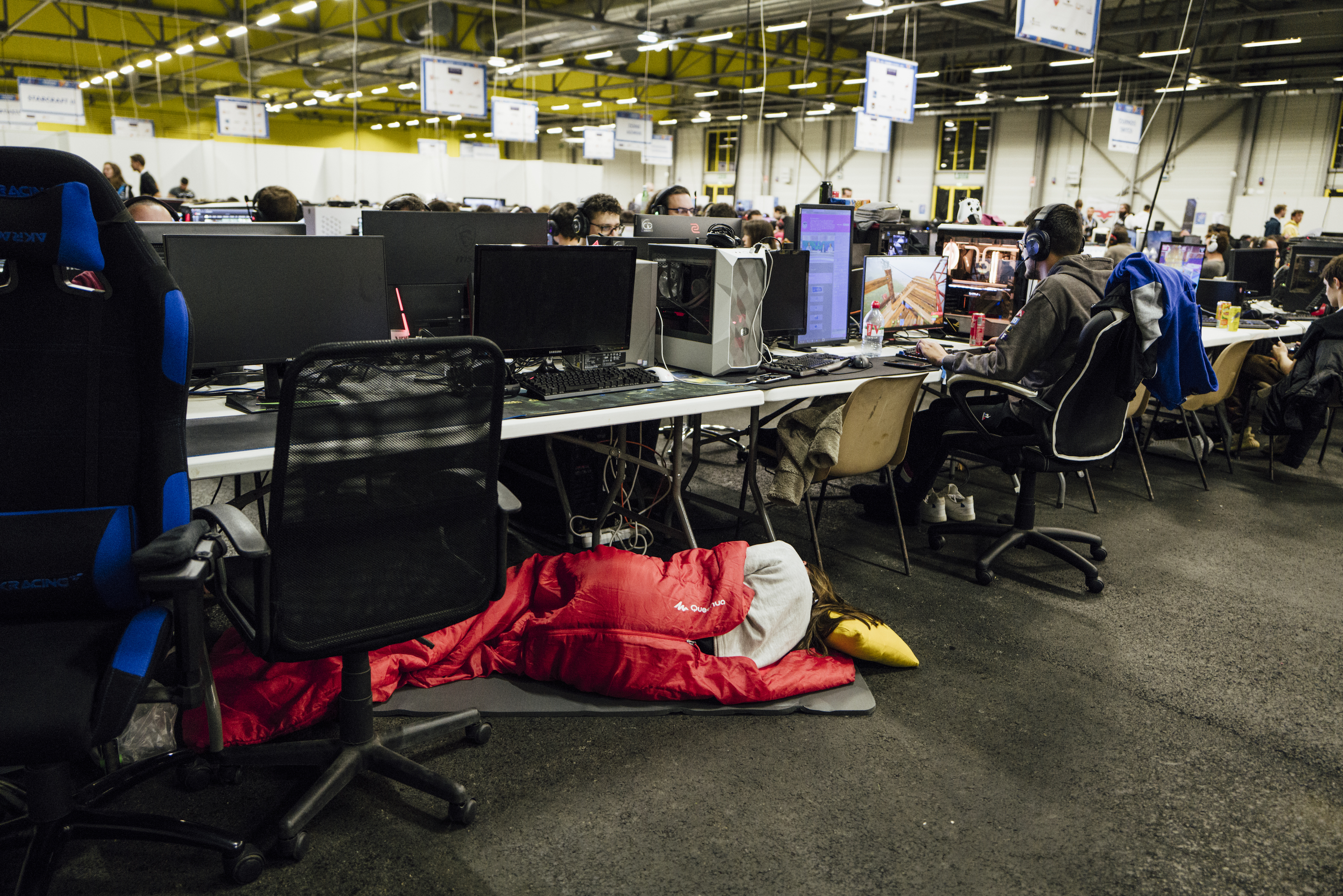 A gamer taking a nap under her desk