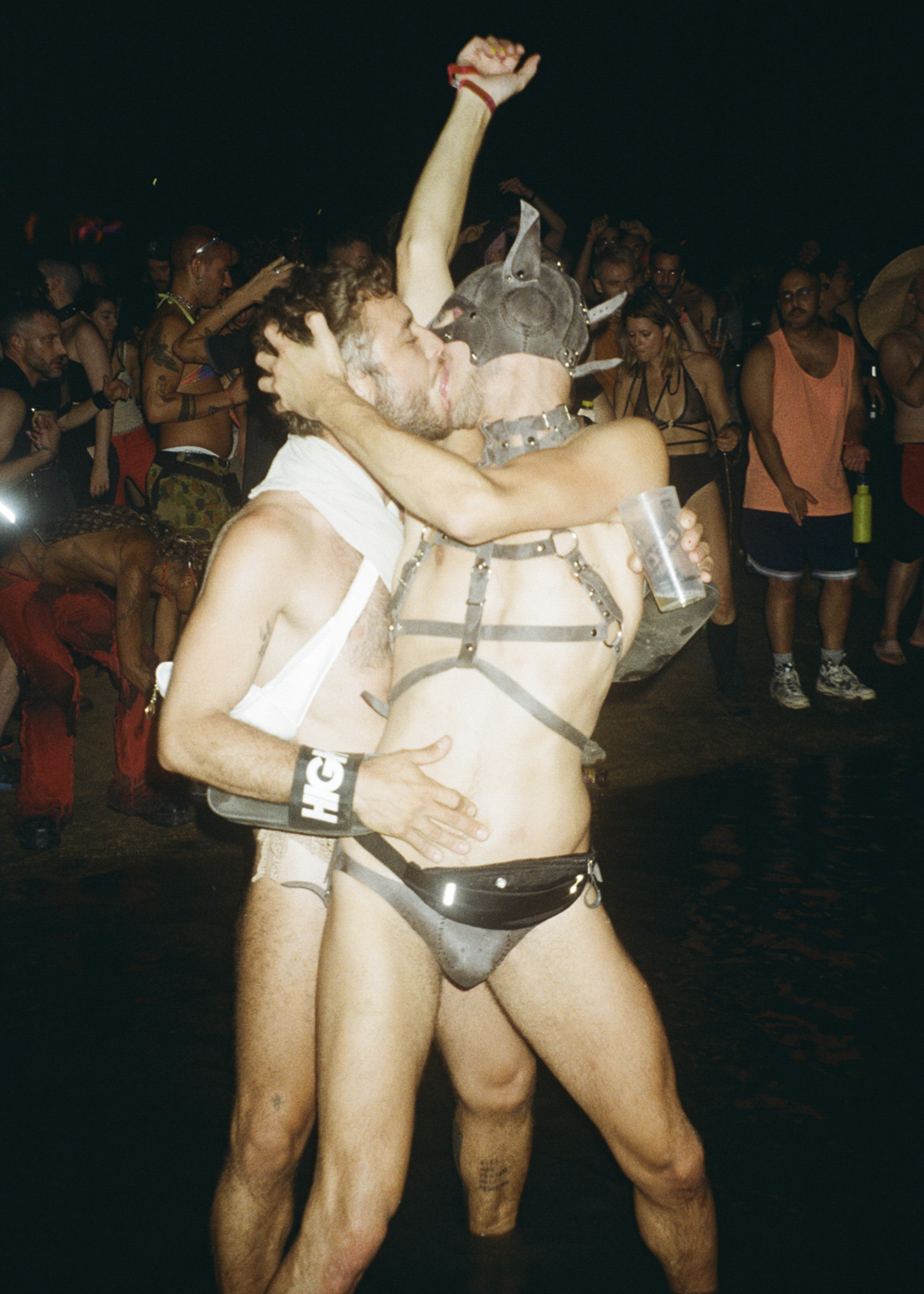Zwei Festivalbesucher in knappen Fetisch-Outfits küssen sich