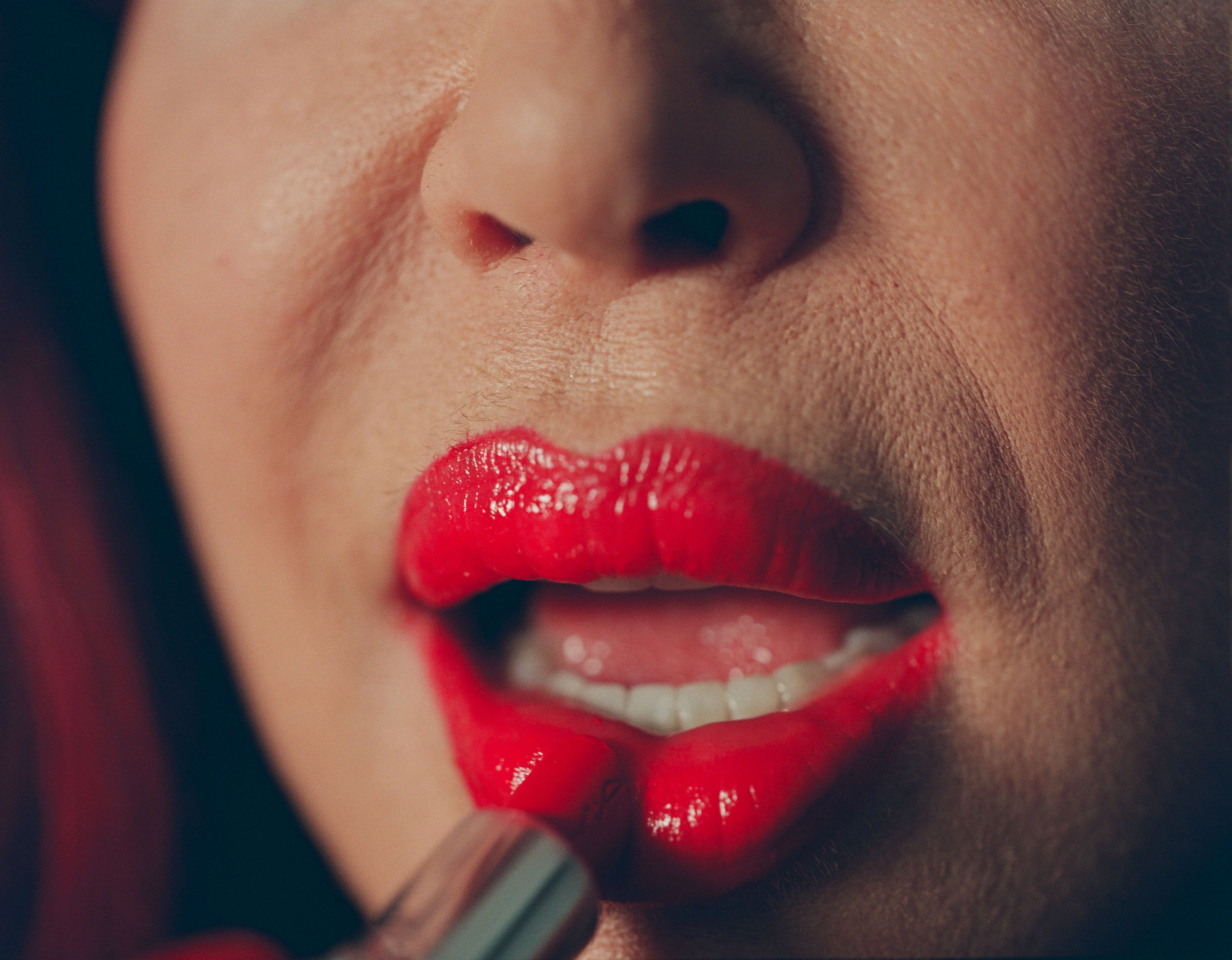 Close up van Vanessa die rode lippenstift op doet