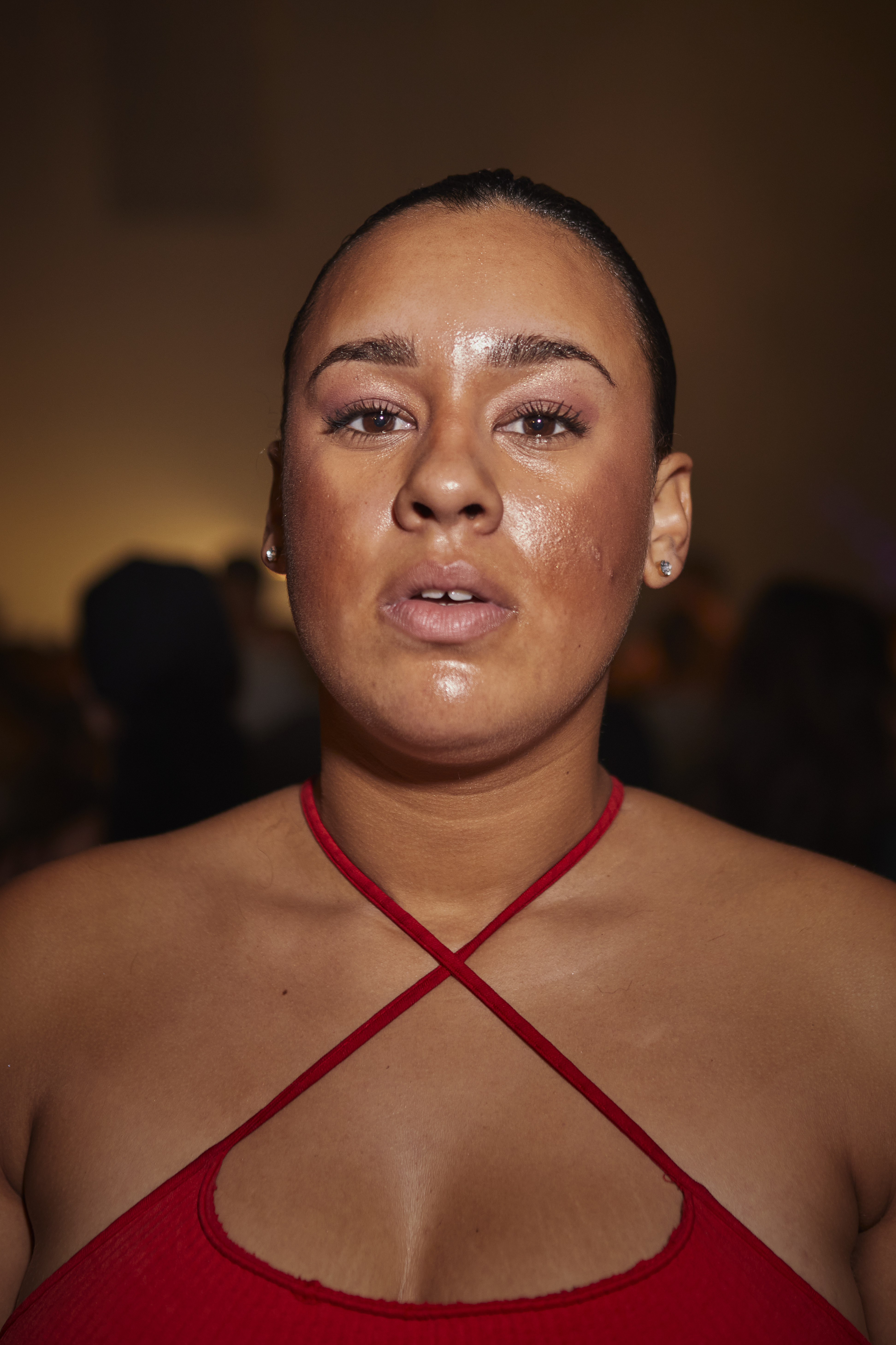 Portrait of a woman with pulled back brown hair, wearing a red top