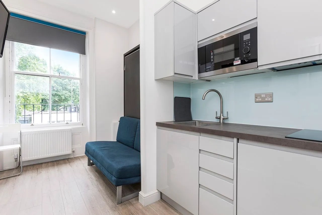 Tiny kitchen next to sleeping area of studio to rent in Bayswater, London