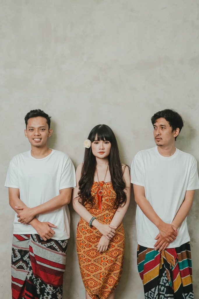 Dua laki-laki dan seorang perempuan berpose bersama