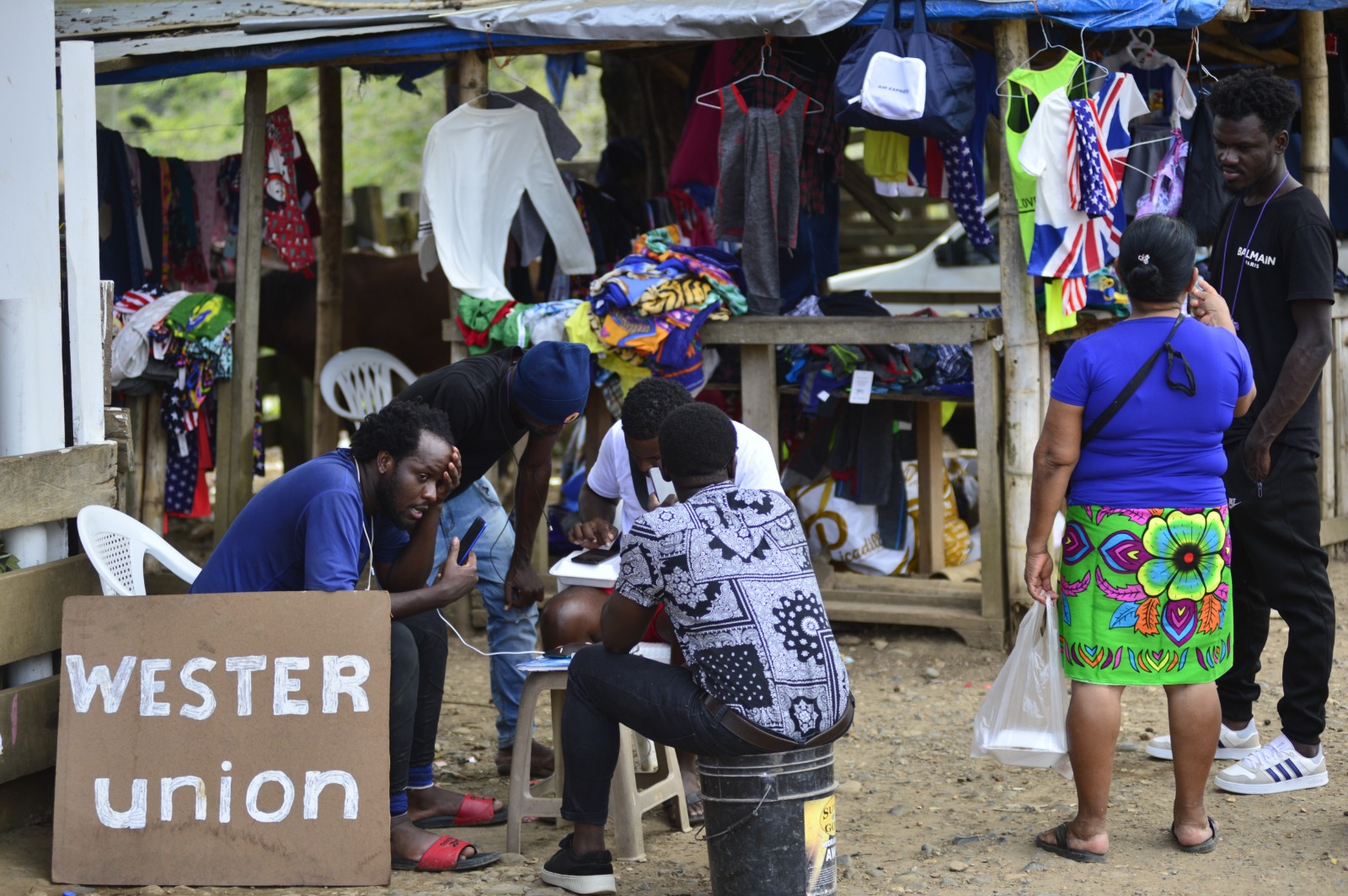 Migrants at a migrant camp at makeshift Western Union stand.