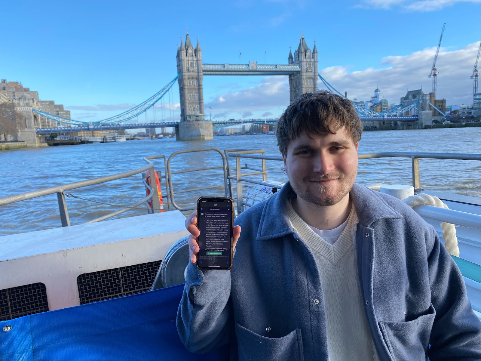 A man holding up ChatGPT on a phone while on a river cruise