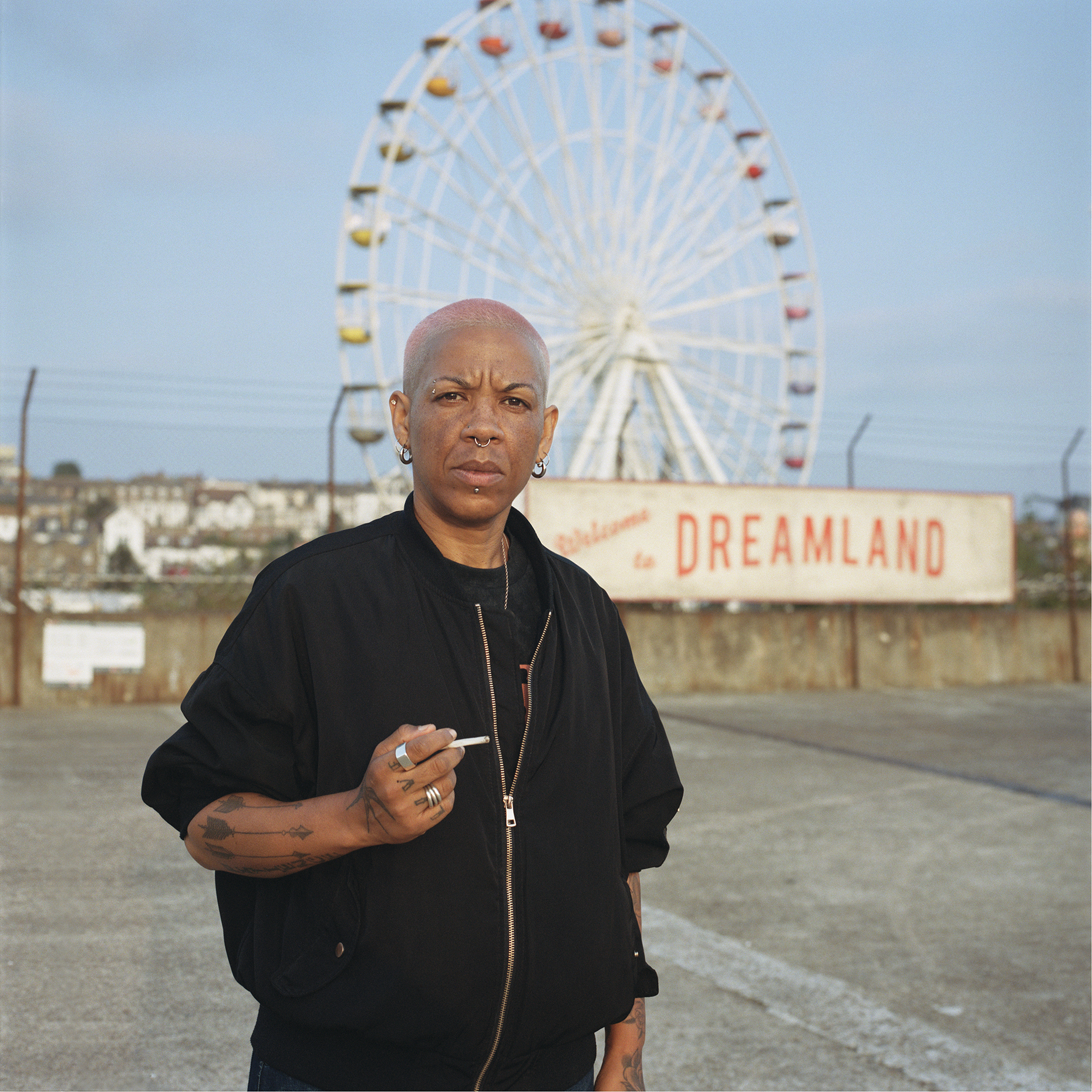 Mel, Margate, Kent: A tattooed butch lesbian holding a cigarette