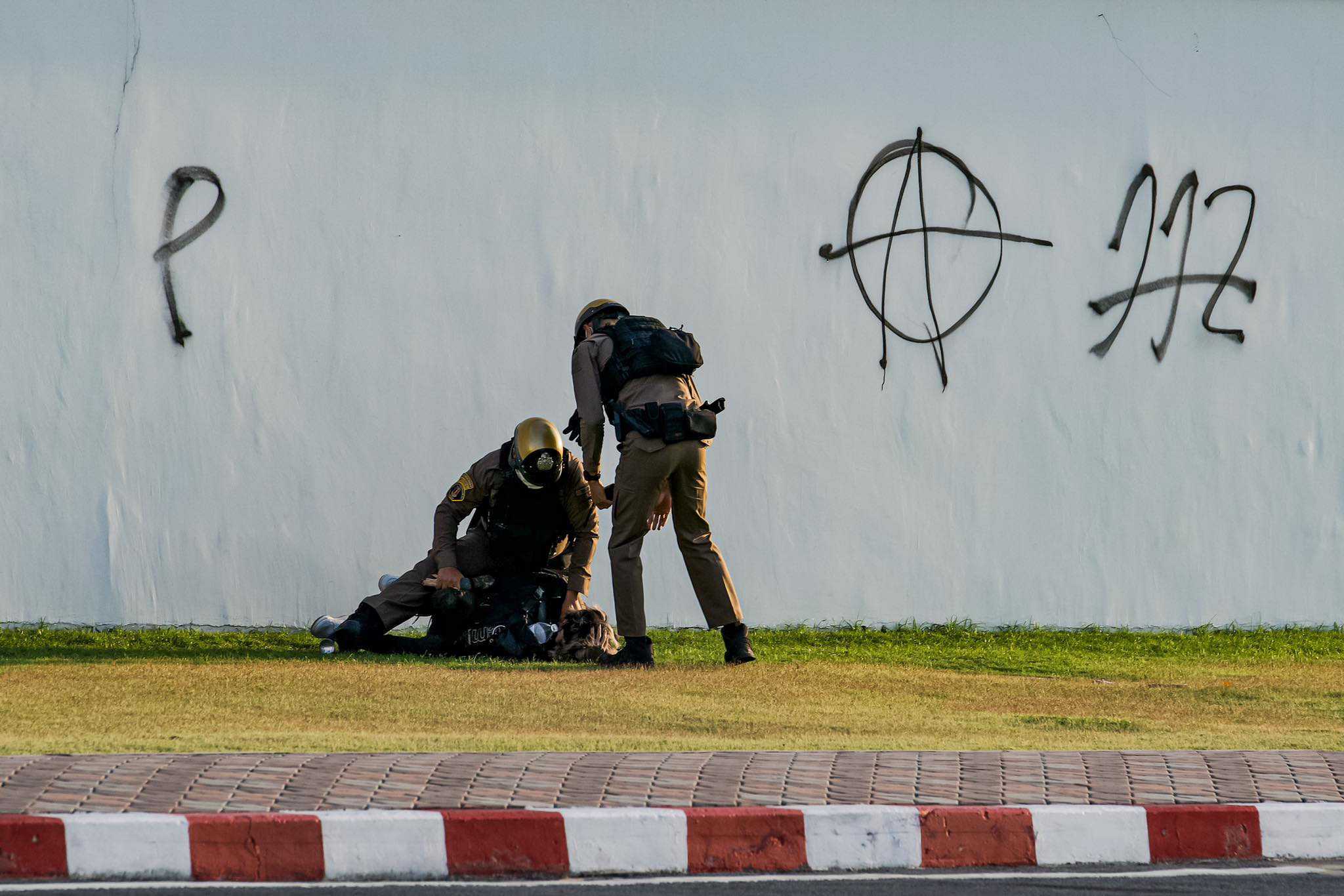 Earn, the Grand Palace graffiti artist, was tackled to the ground during his arrest. A police officer placed his knee on Earn's head even though he was not resisting arrest, said Thai Lawyers for Human Rights. Photo: Ginger Cat