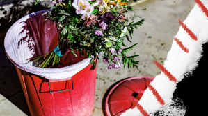 flowers in red garbage bin on street