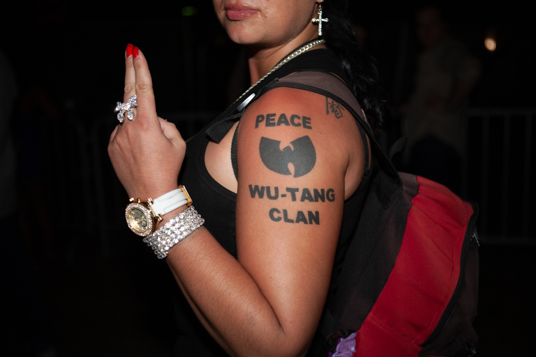 Een vrouw met een Wu Tang Clan-tattoo en fonkelende sieraden bij Rock the Bells op Governors Island, NY, 2010.