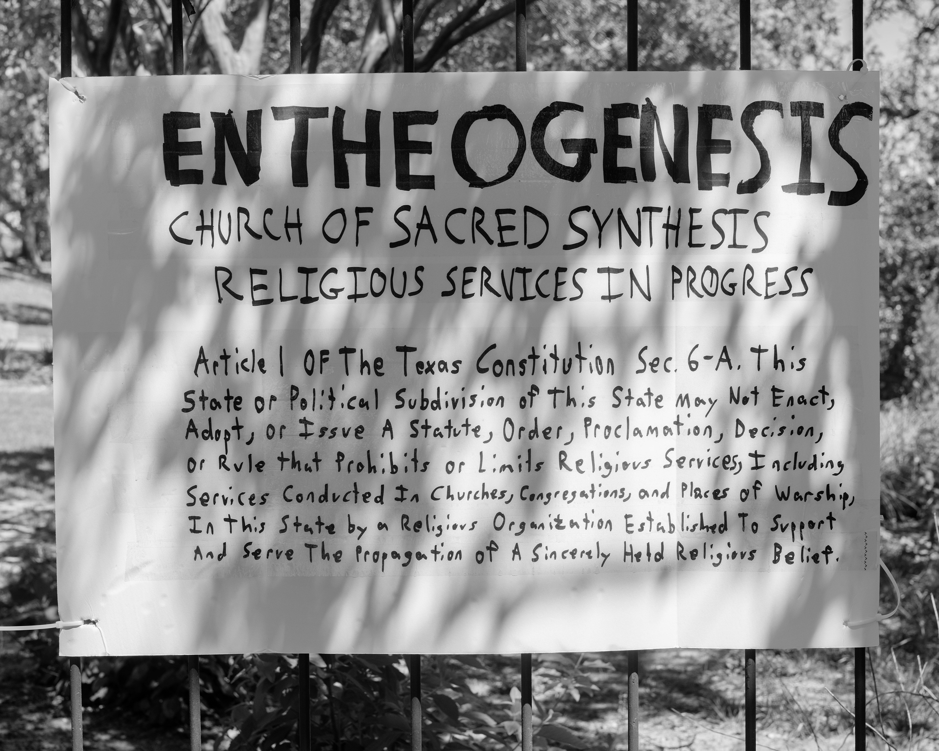 Een handgeschreven bord van de Entheogenesis Church waarop staat: