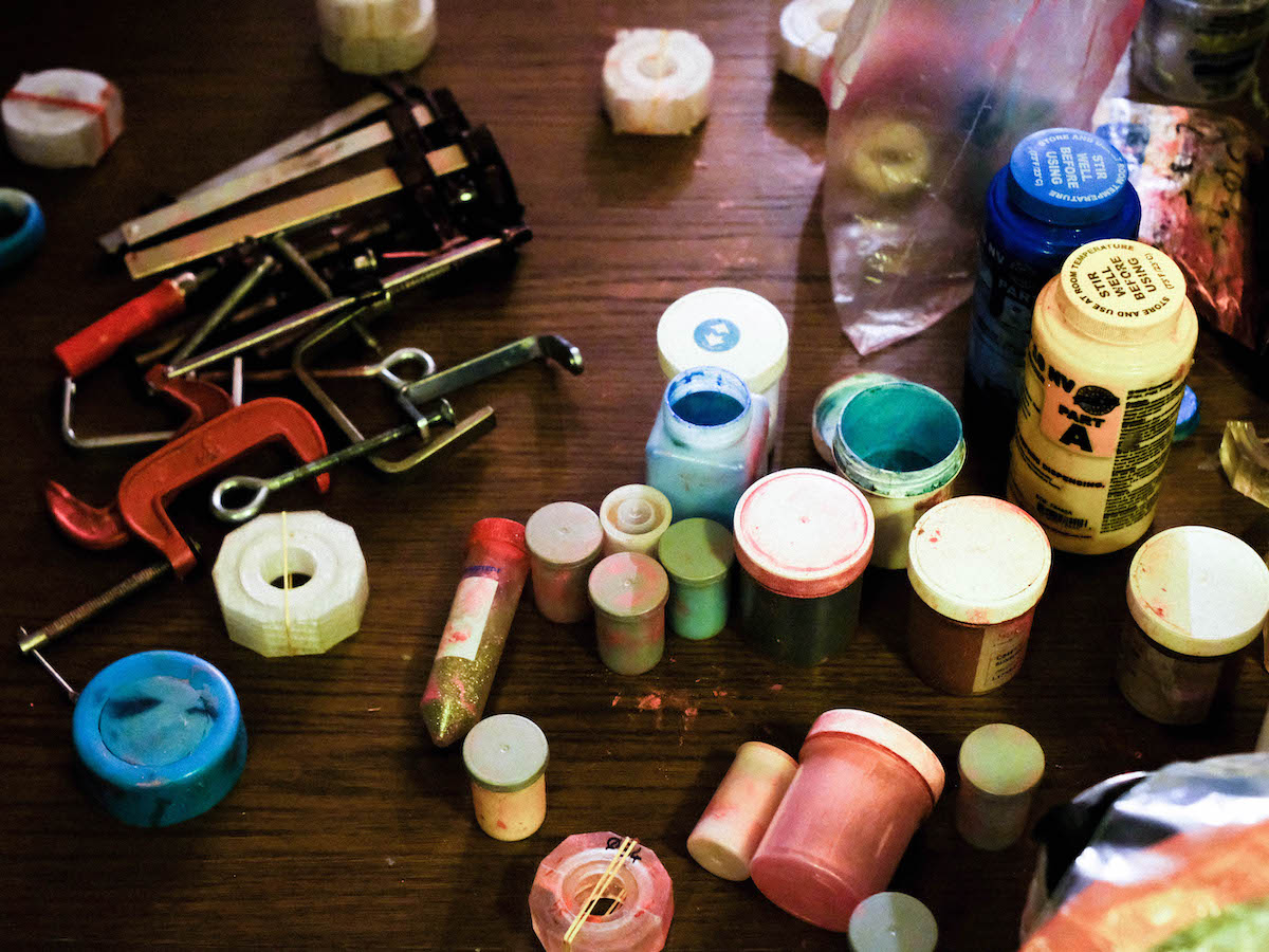 Heat-based Otoko Contraception – a number of moulds, dyes, clamps glitter and other tools on top of a wooden table