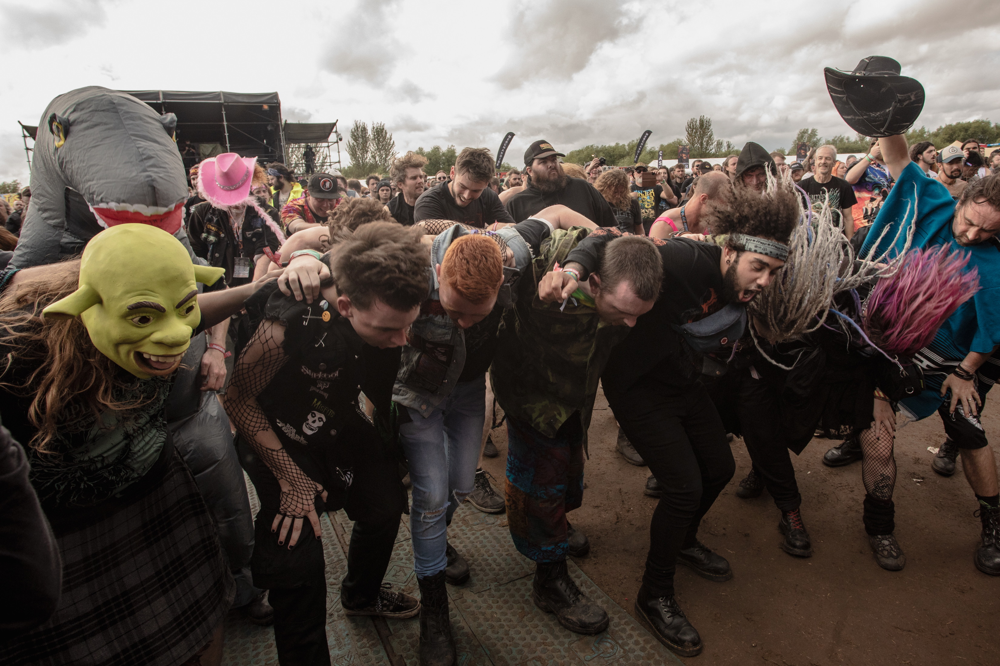 Eine Gruppe junger Menschen hält sich beim Headbangen in den Armen