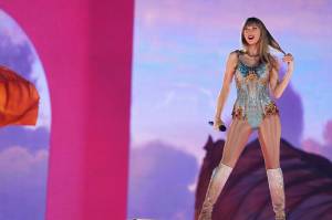 Taylor Swift bei einem Auftritt auf ihrer Eras Tour. Sie trägt einen glitzernden Bodysuit und spielt mit ihrem Haar. In dem Artikel geht es darum, wie sie ihren Fans immer wieder Rätsel aufgibt.
