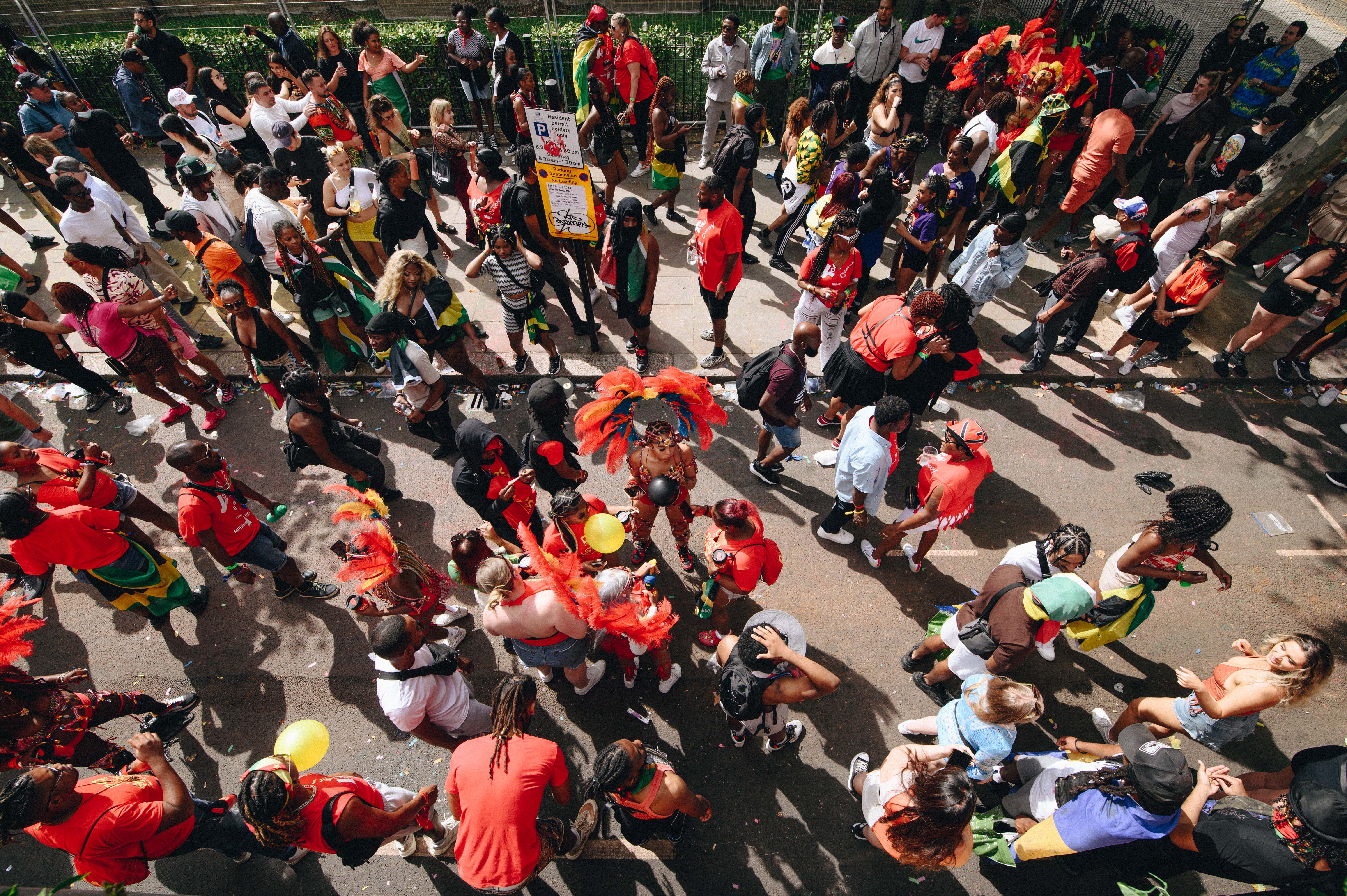 Notting Hill Carnival 2023, London: Aerial shot of people dressed in red