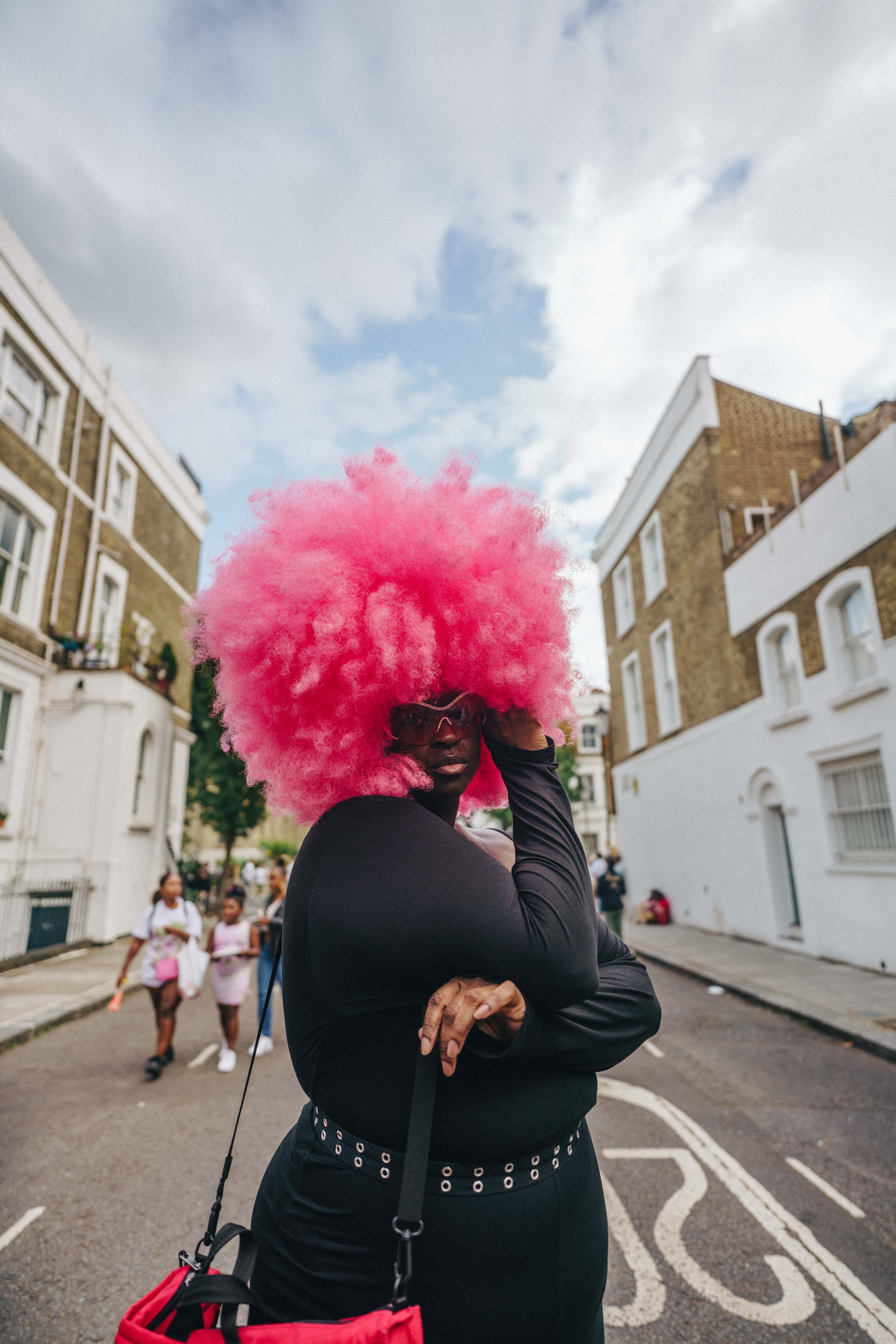 Notting Hill Carnival 2023, London: A woman with a pink afro poses