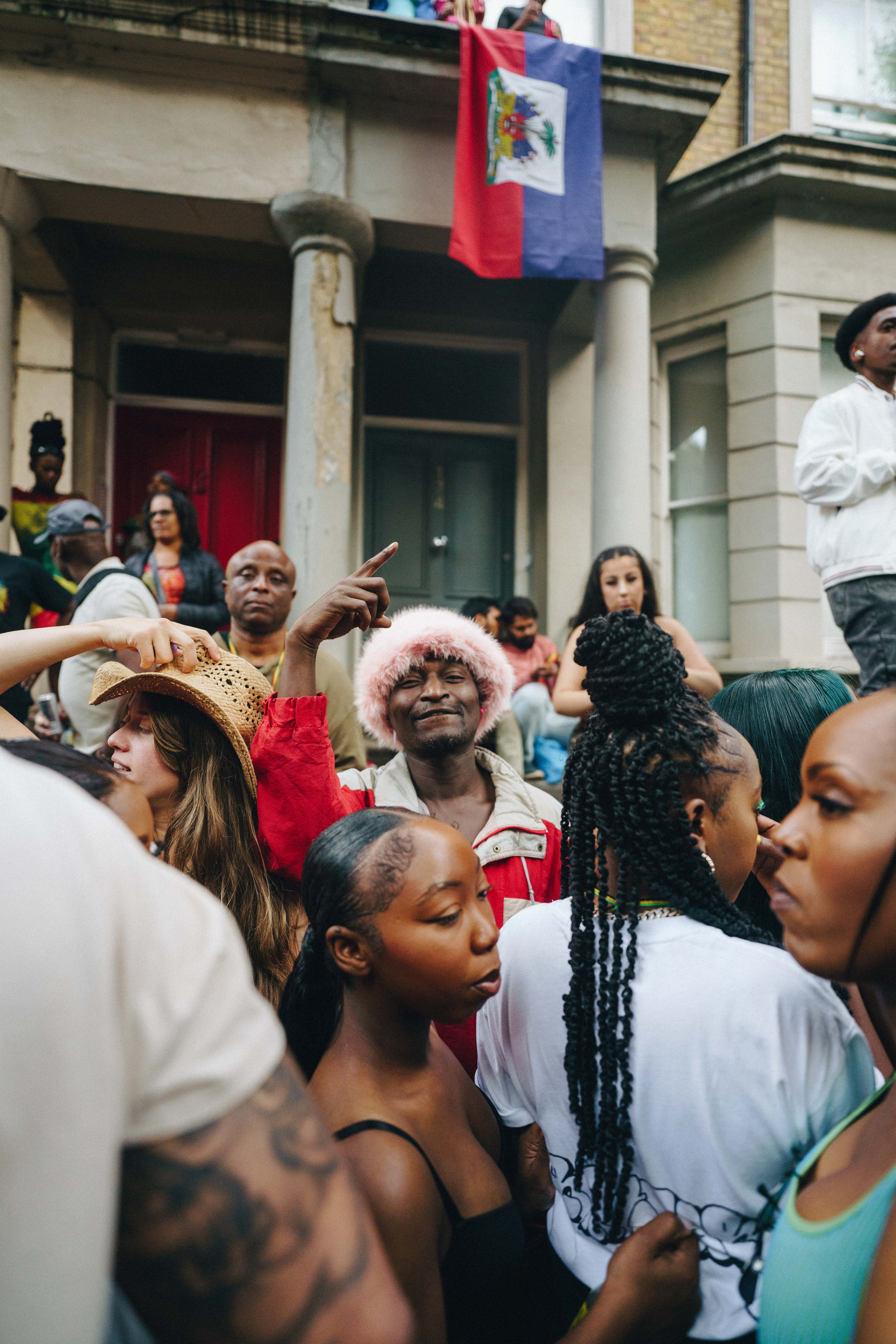Notting Hill Carnival 2023, London: A man in a furry pink hat smiles at the camera