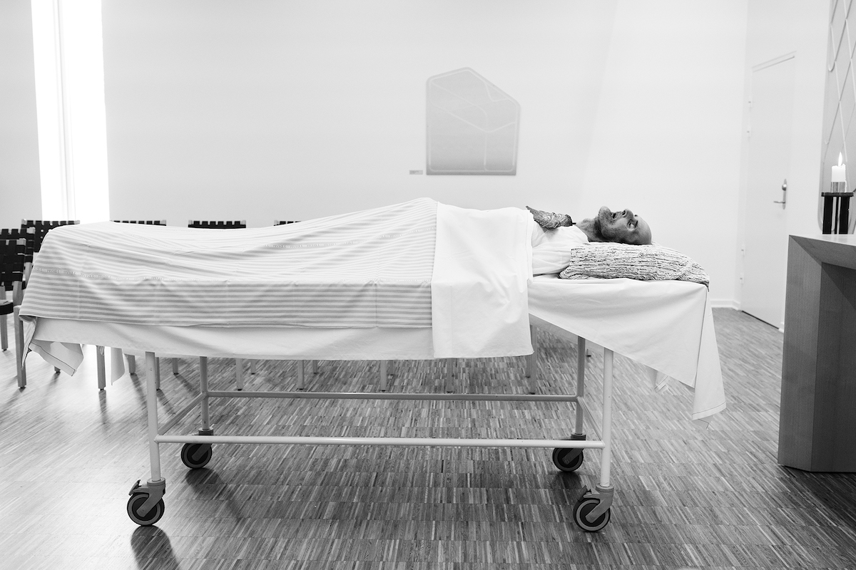 Mikkel Hørlyck, Jørgen, a Mystery – Pedersen lying on a hospital bed in a chapel