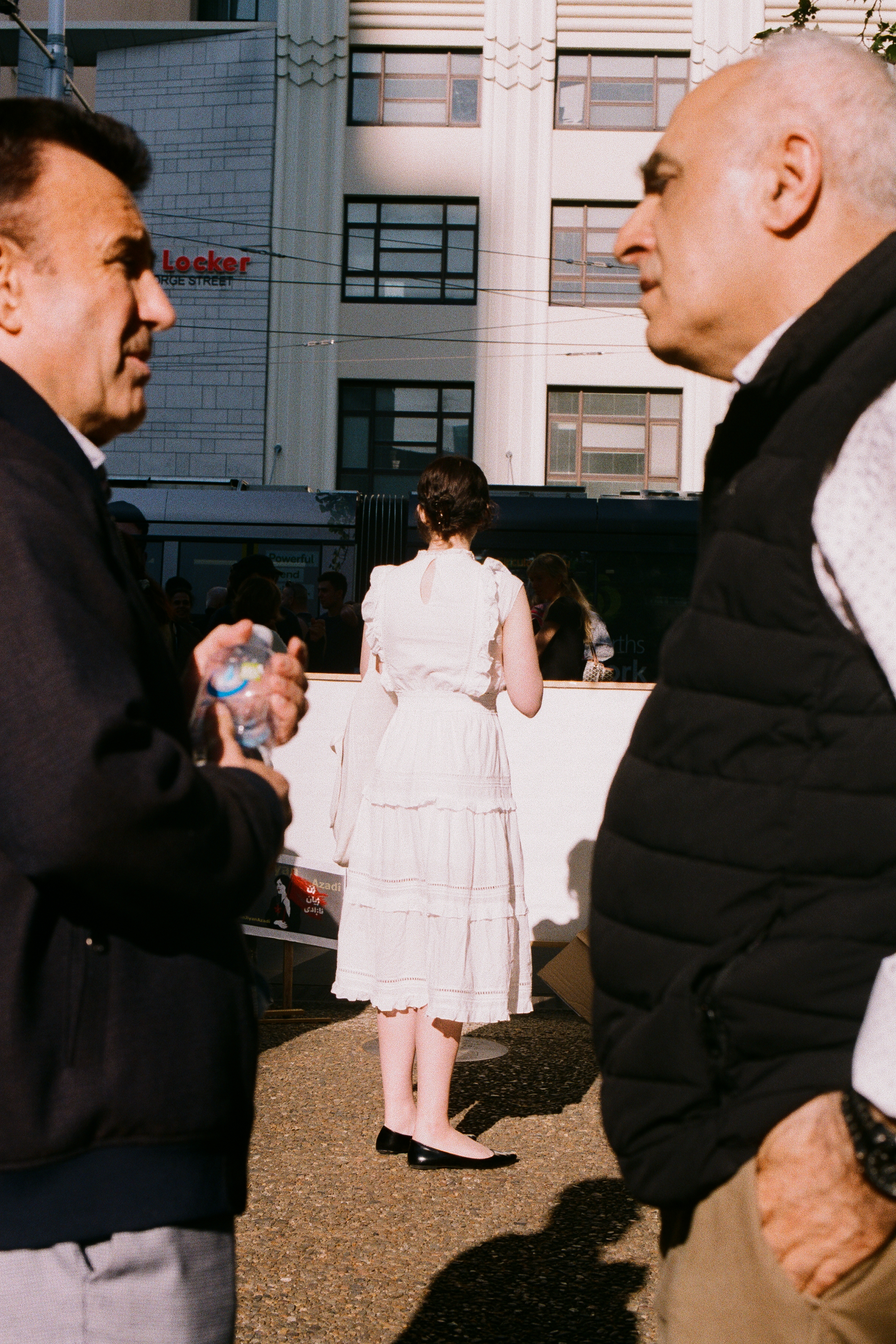 Men talking with woman in the background middle ground