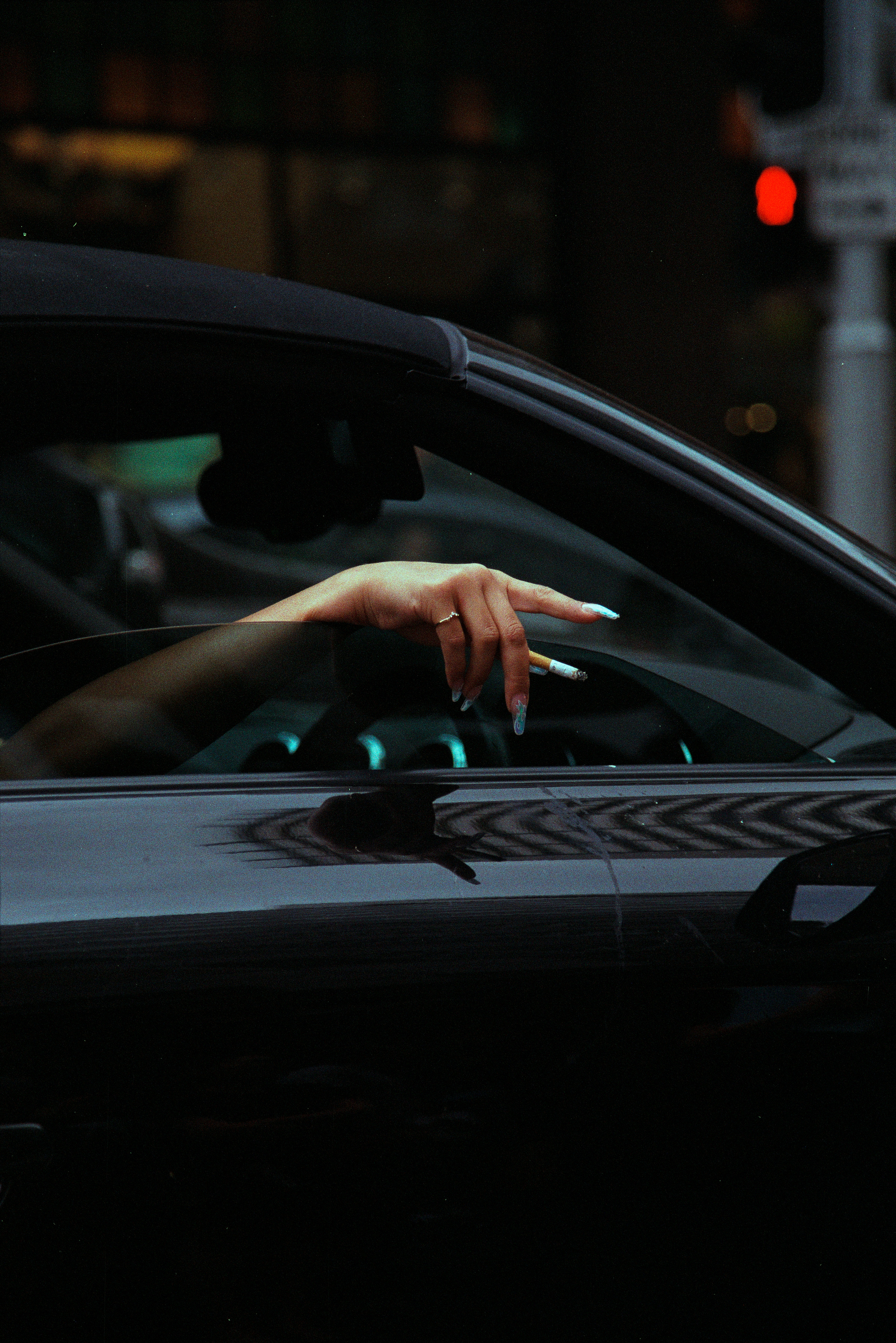 Woman hangs cigarette out of car window