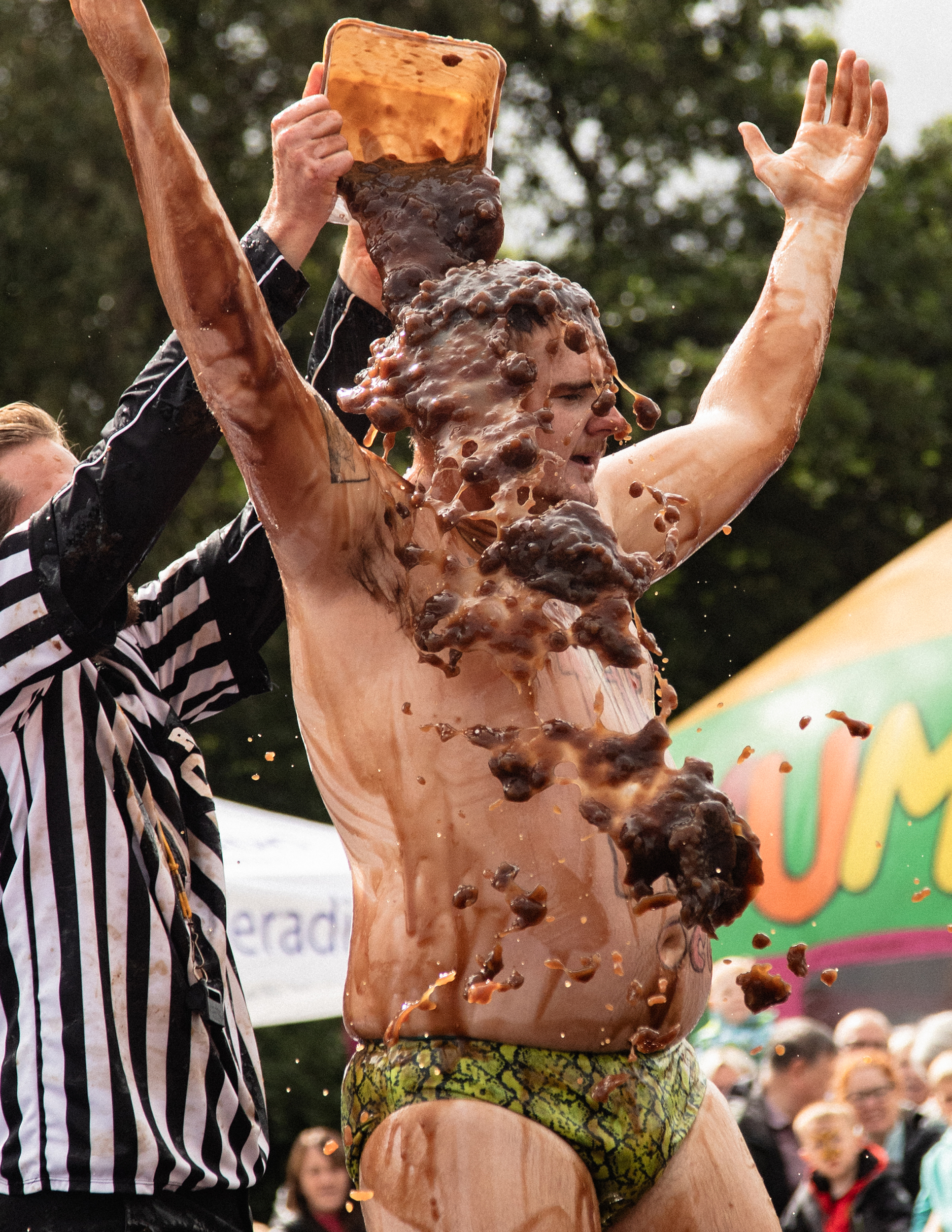 Bratensoßen-Wrestling-WM – ein Mann inn Speedos wird mit Bratensoße übergossen