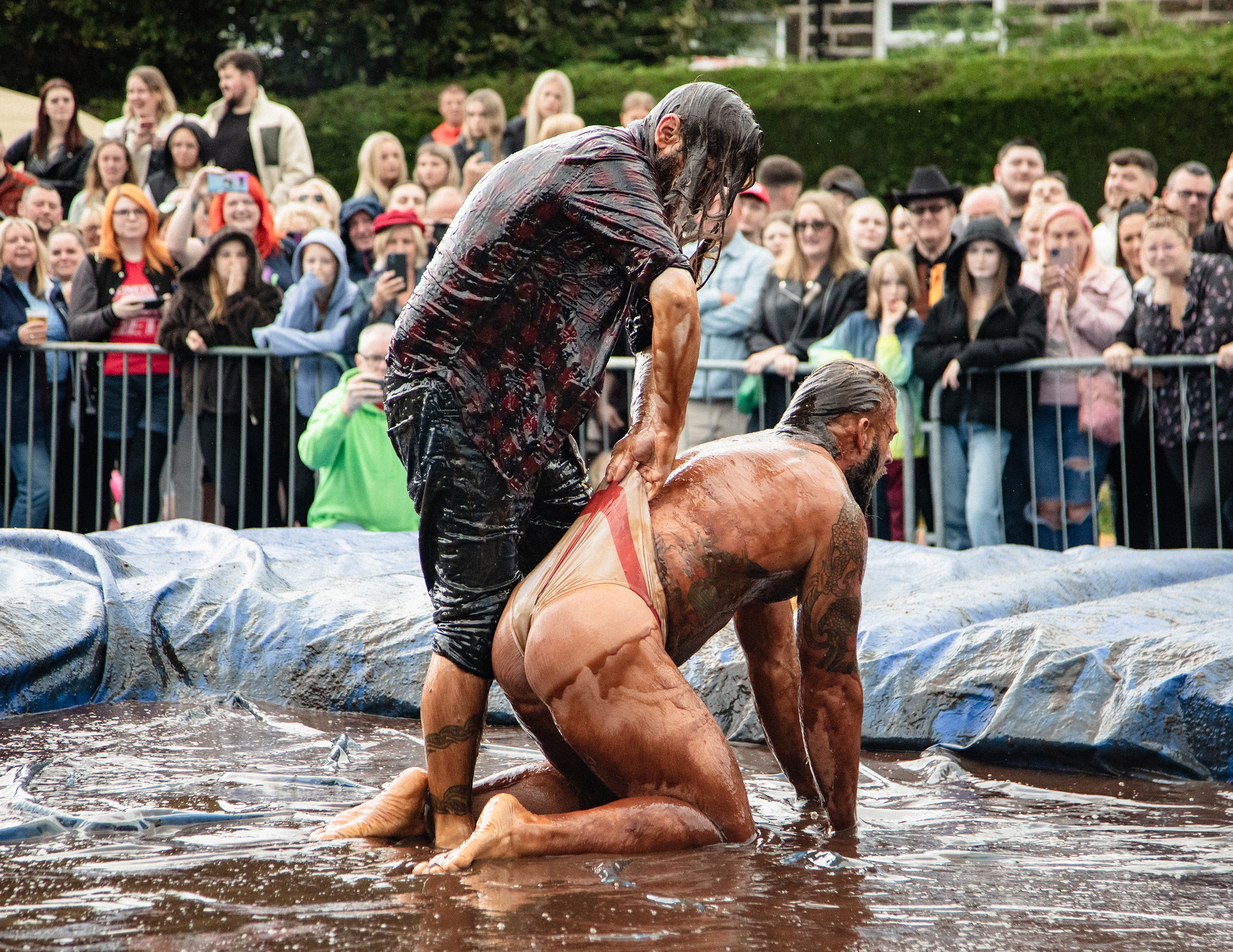 Bratensoßen-Wrestling-WM – Zwei Männer die in einem mit Bratensoße gefüllten Wrestling-Ring miteinander ringen