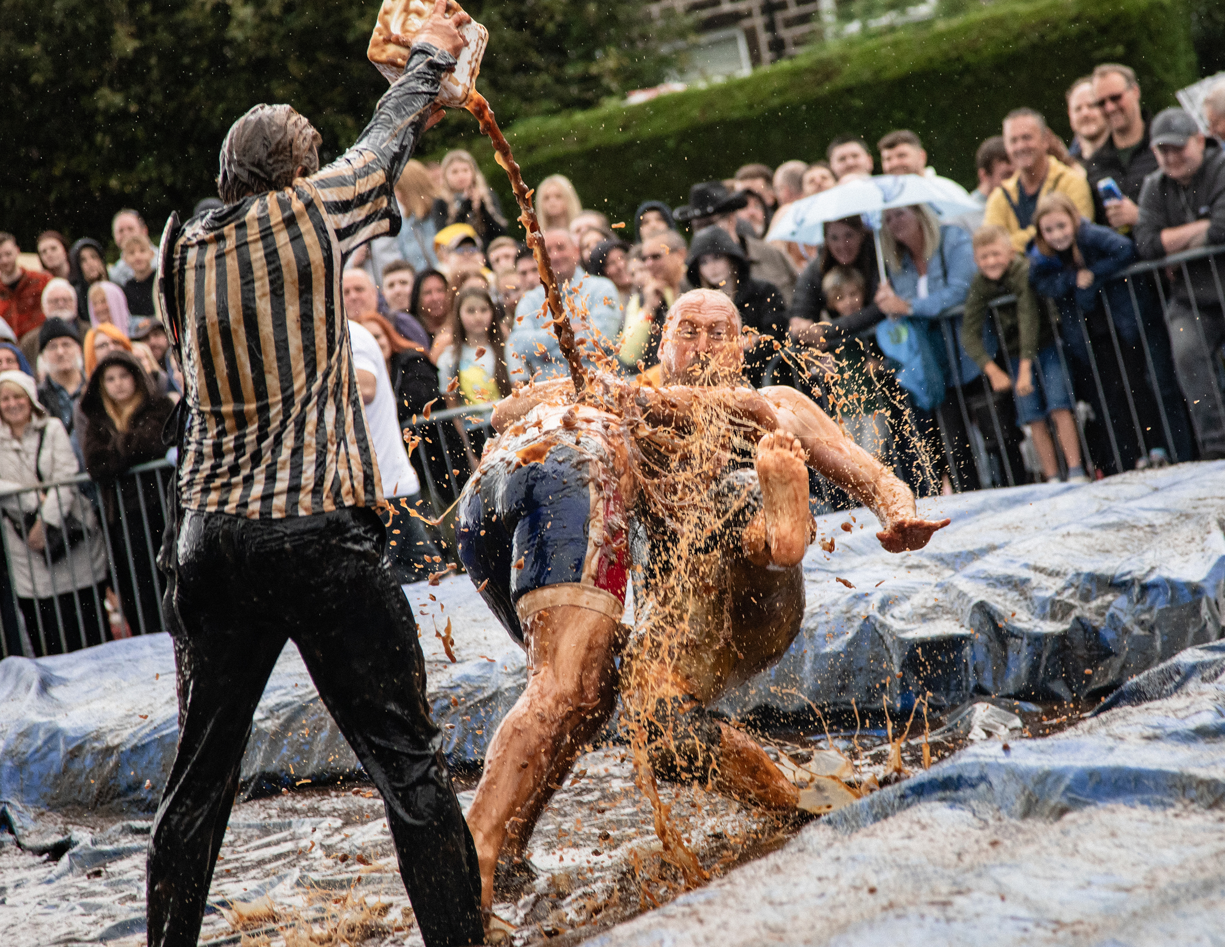 Bratensoßen-Wrestling-WM – Zwei Männer die in einem mit Bratensoße gefüllten Wrestling-Ring miteinander ringen