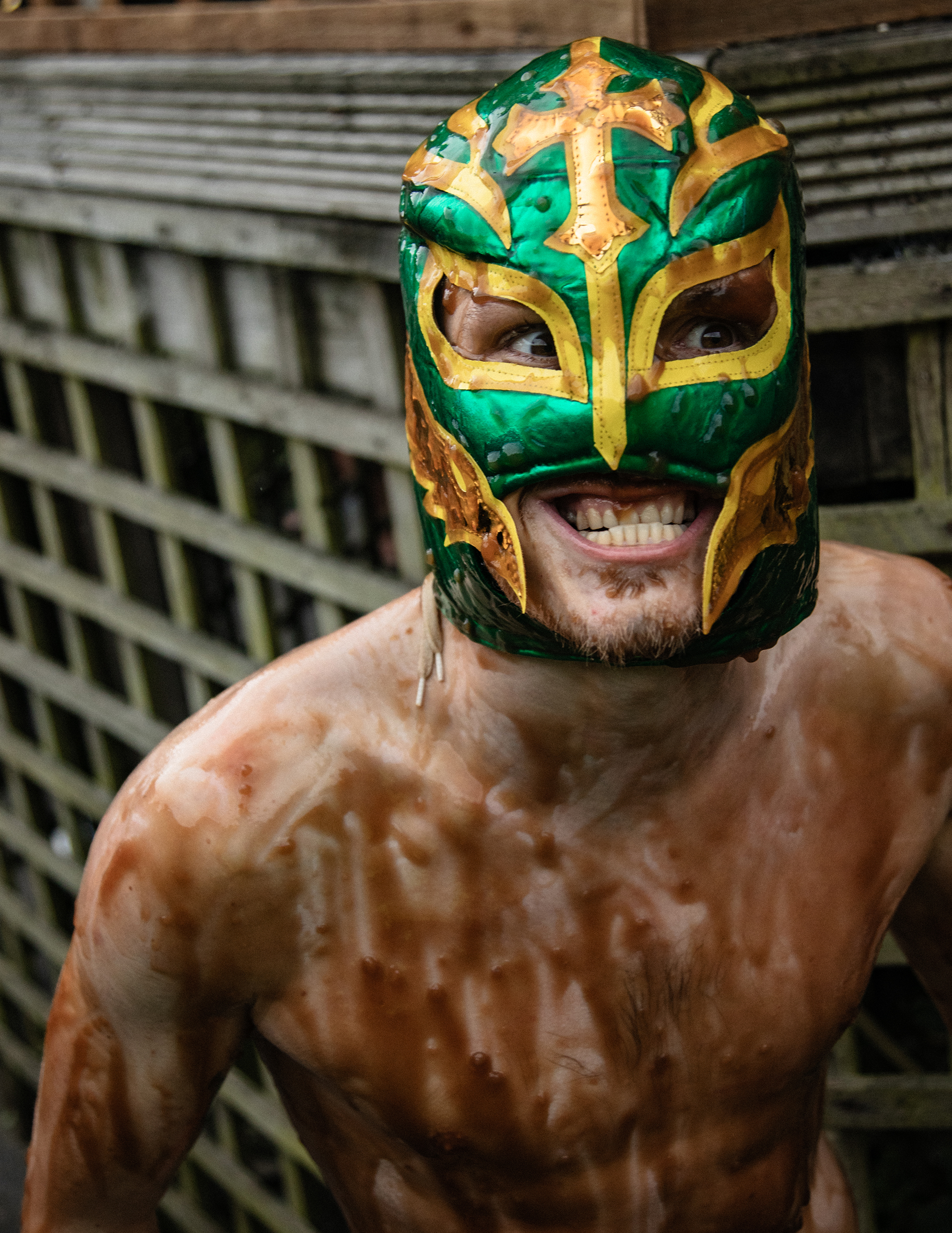 Bratensoßen-Wrestling-WM – Ein Mann ohne Shirt mit einer mexikanischen Wrestlingmaske ist über und über mit Bratensoße übergossen
