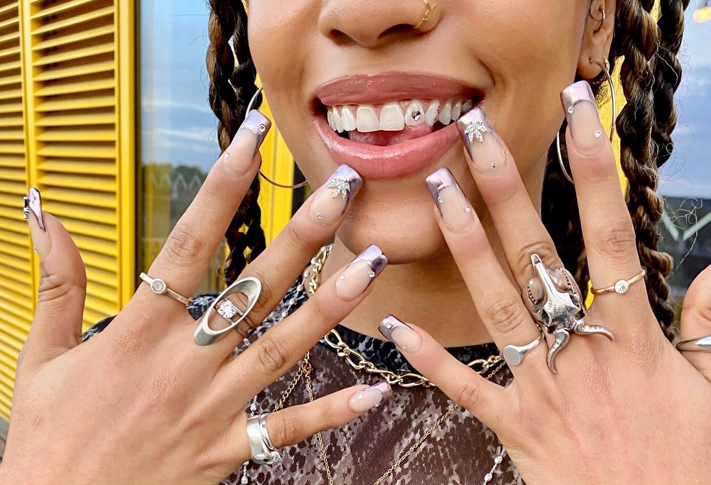 Woman holding up manicure with tooth gem smile
