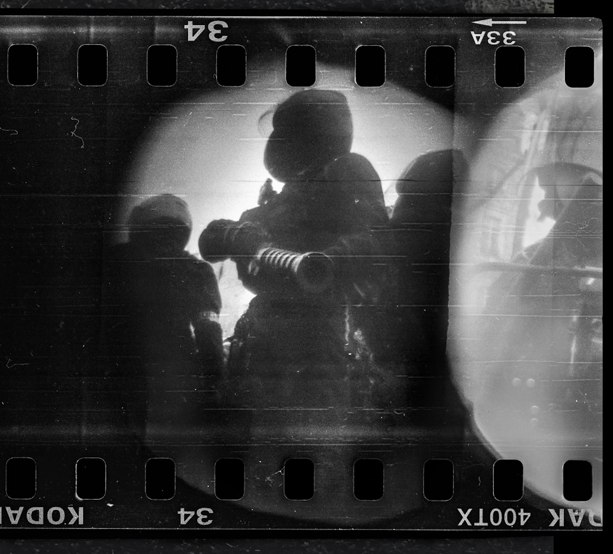 Steven Monteau photos with police weapons: black and white negative of a riot police agent holding a weapon