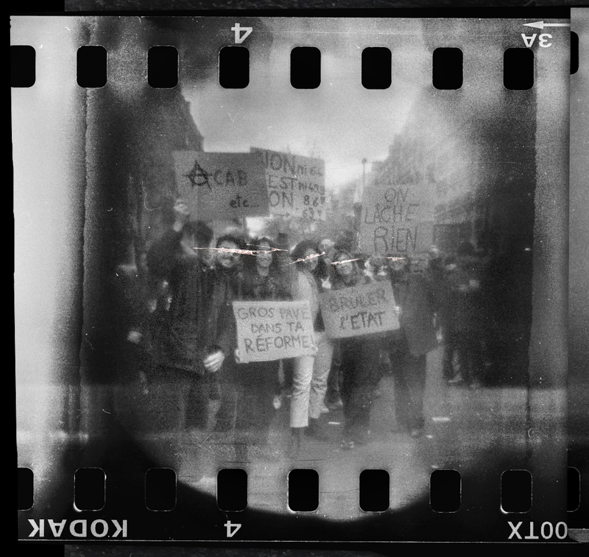 Steven Monteau photos with police weapons: black and white negative of a protest with people holding protest boards