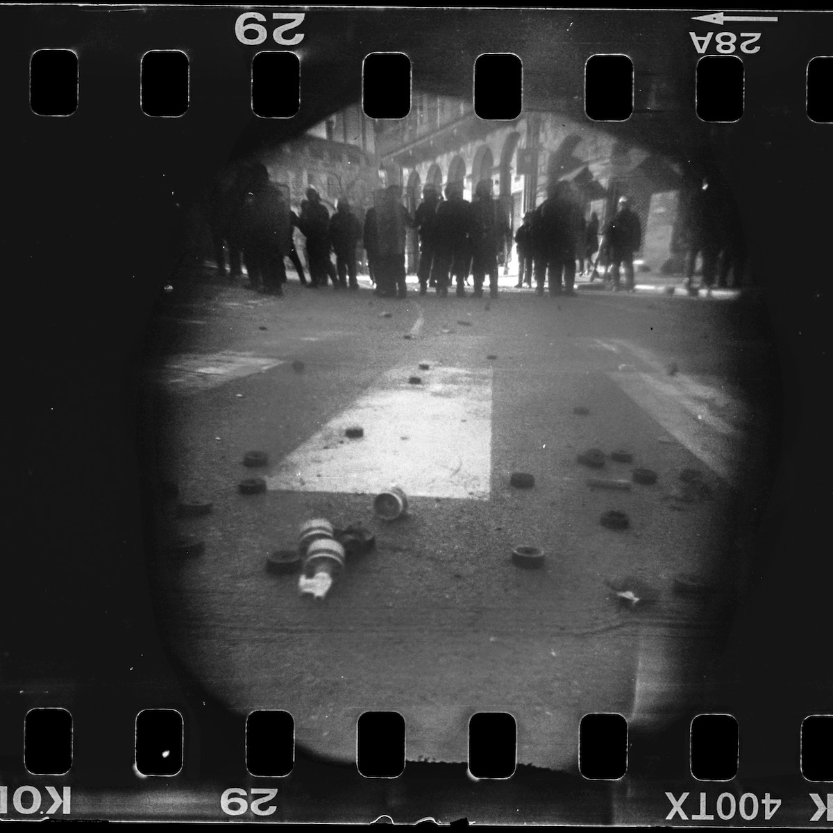 Steven Monteau photos with police weapons: black and white negative of a riot with police in line and weapons on the floor