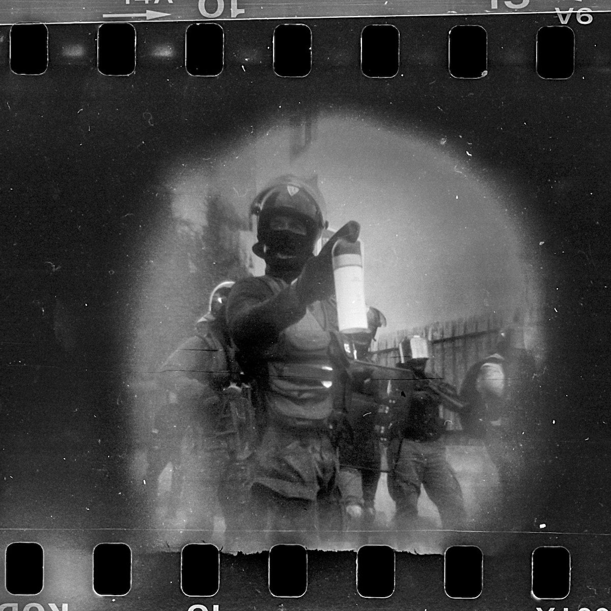 Steven Monteau photos with police weapons: black and white negative of police at a protest