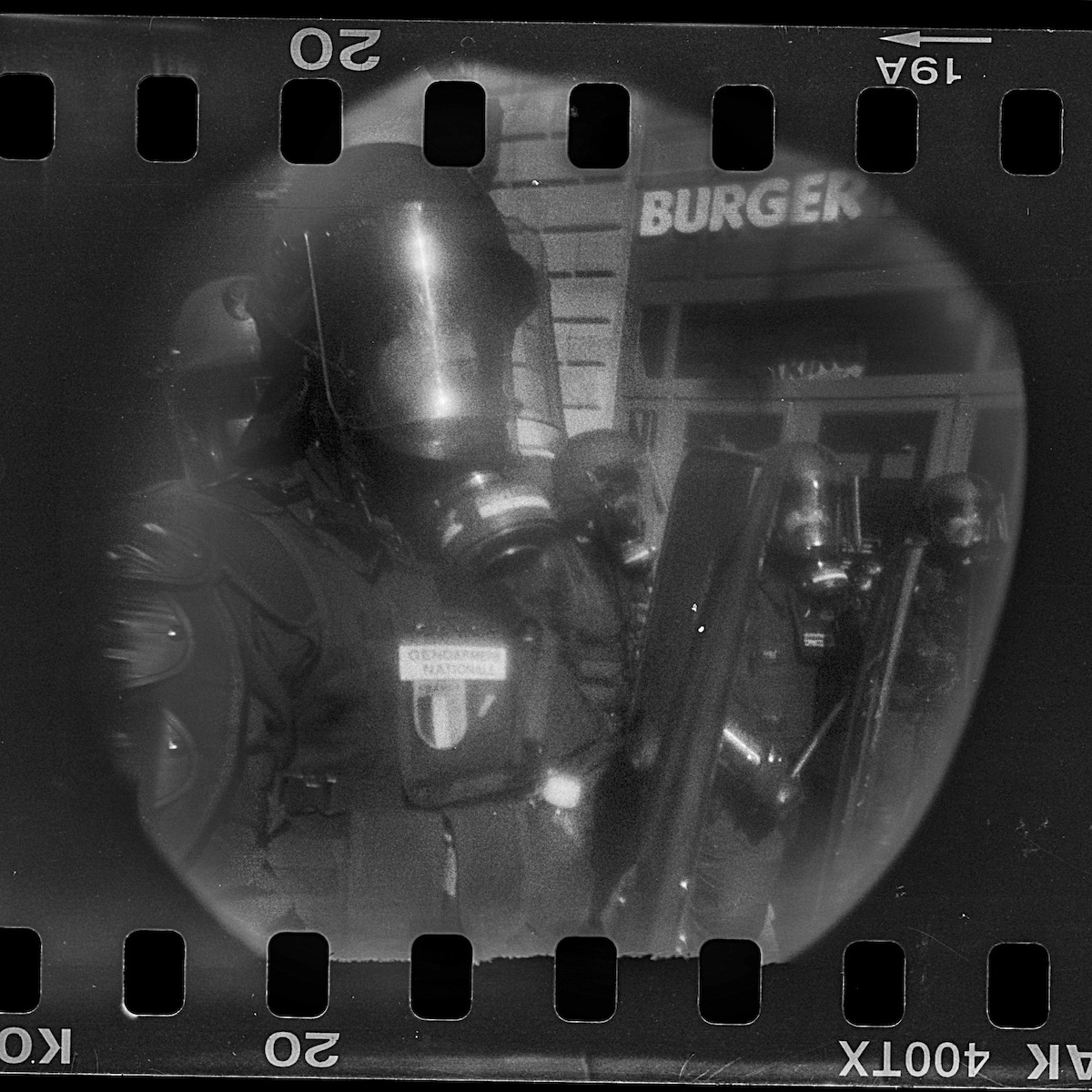 Steven Monteau photos with police weapons: black and white negative of police at a protest