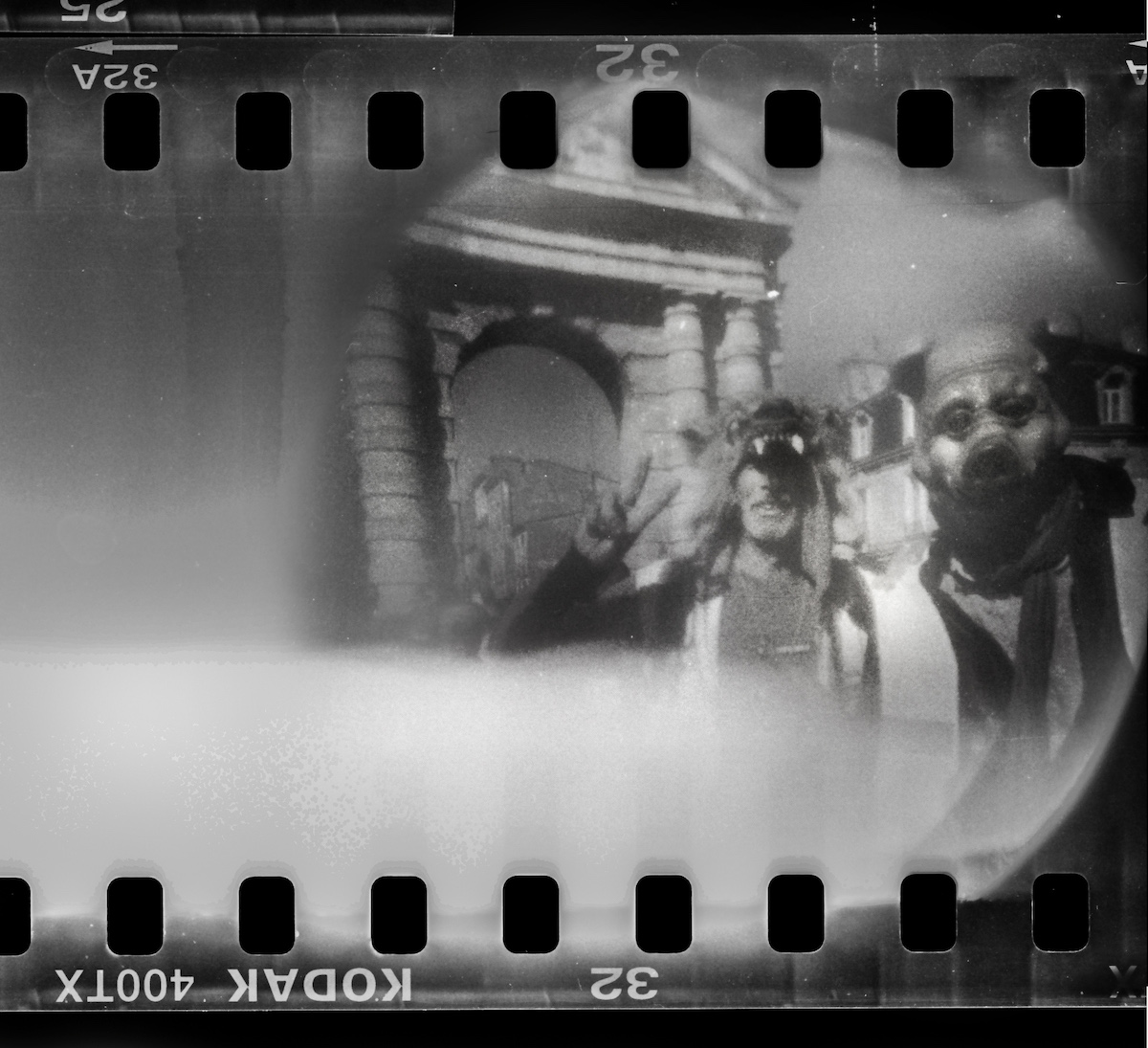 Steven Monteau photos with police weapons: black and white negative of two people dressed up at a protest
