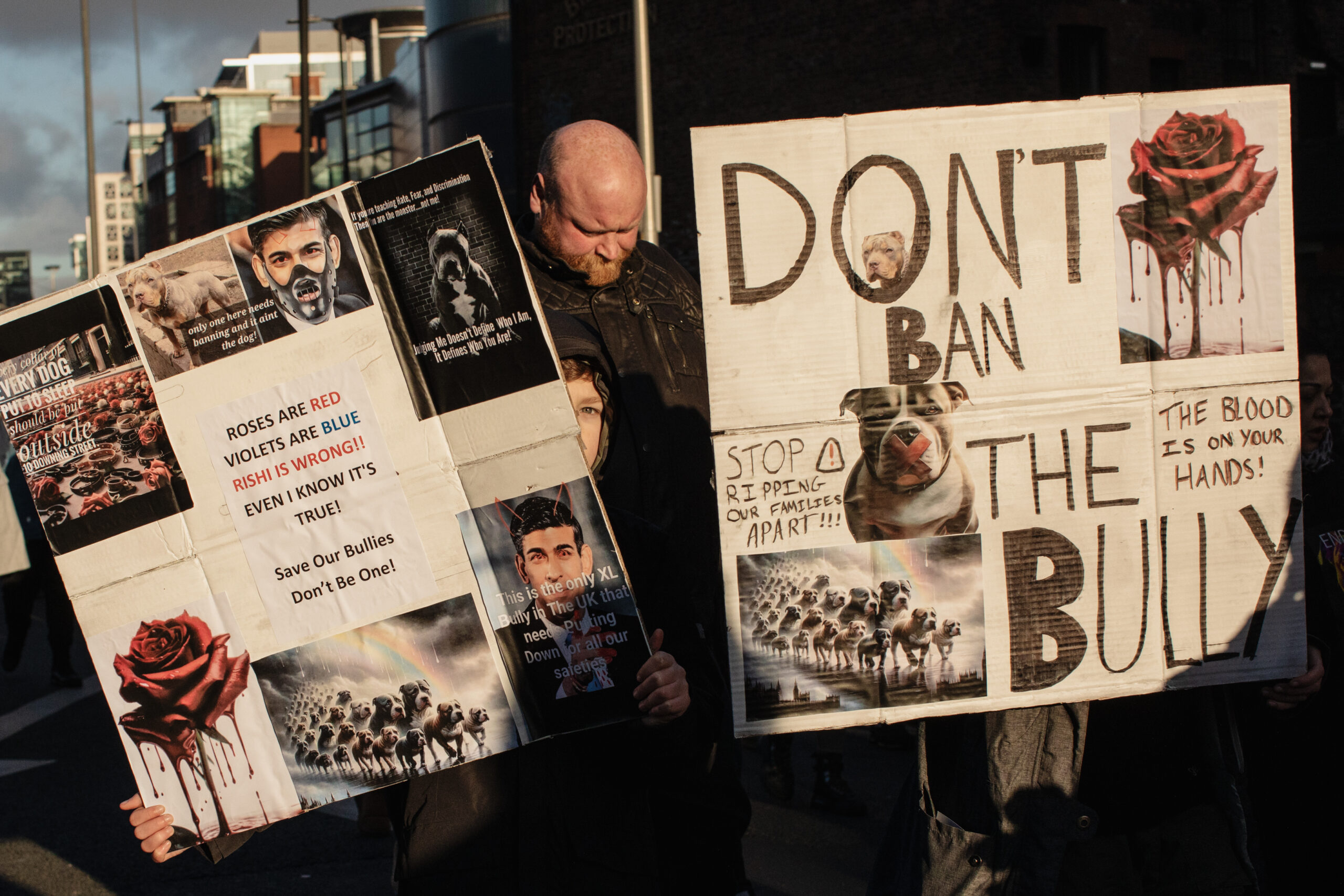 Manchester, UK: Two protesters hold up signs at an XL Bully protest