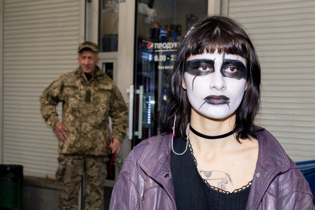 A goth poses for a photo next to a soldier