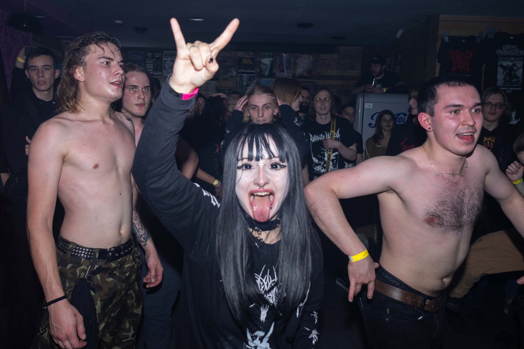 A girl poses for the photo while others dance around her