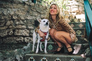 The author kneels to pose with a dog