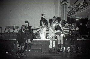 A group of young people sit on a stage at a birthday party in Hulme, England